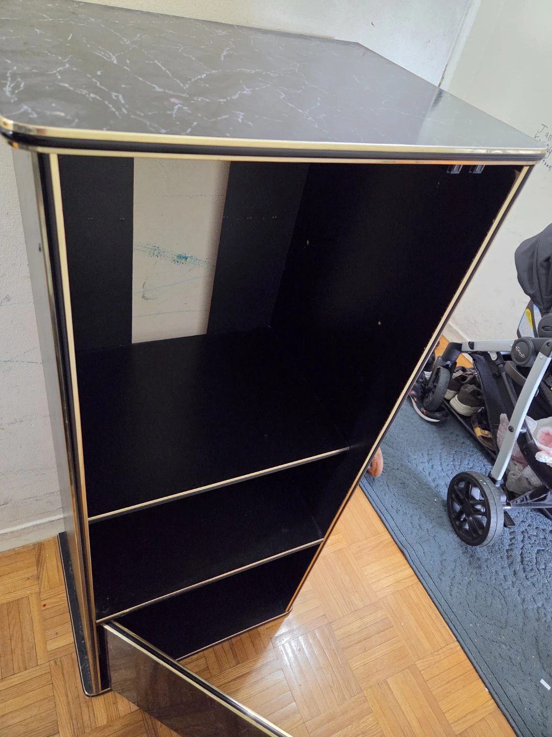 Black display shelf with gold trim