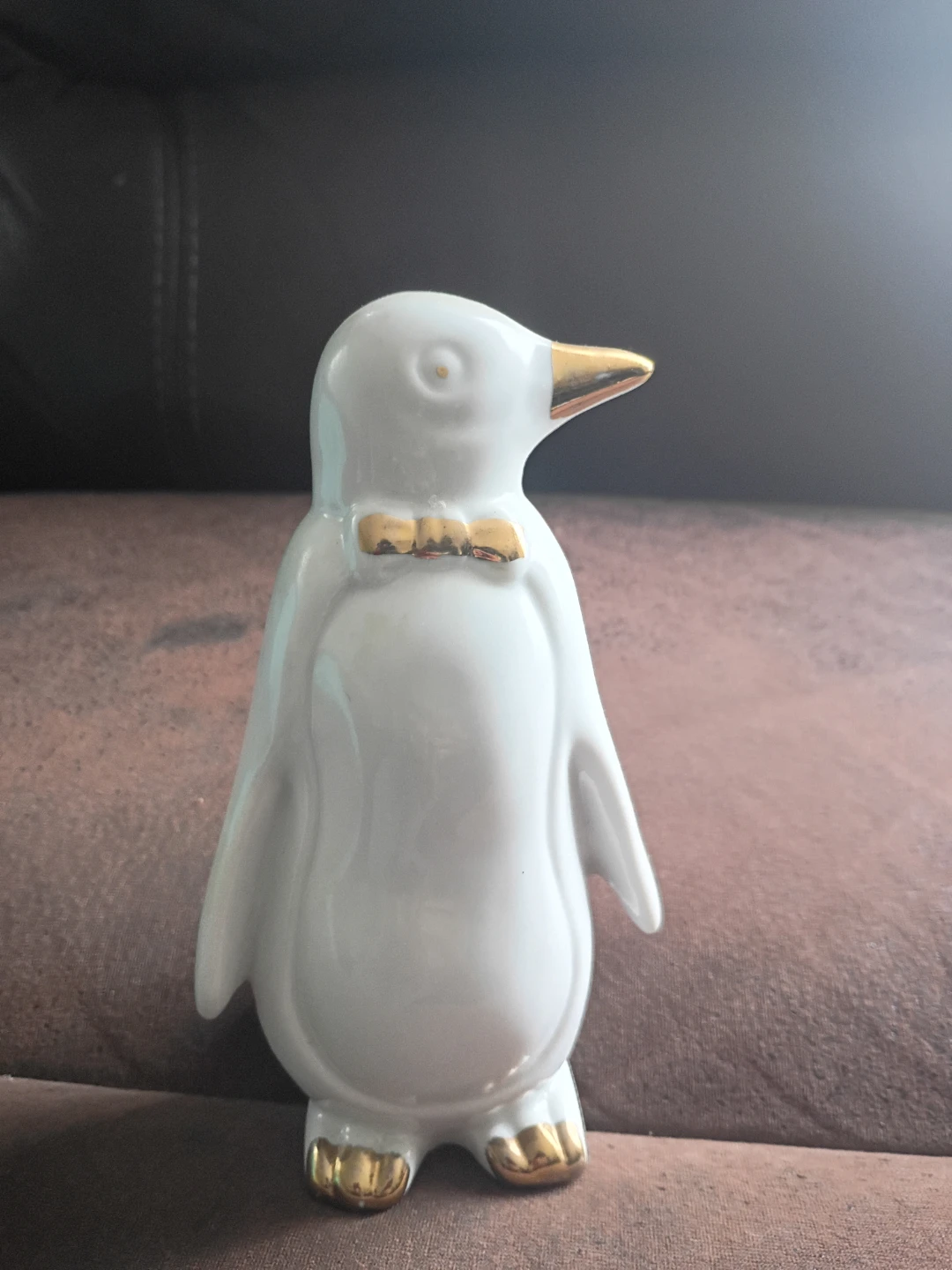 White ceramic penguin figurine with gold accents