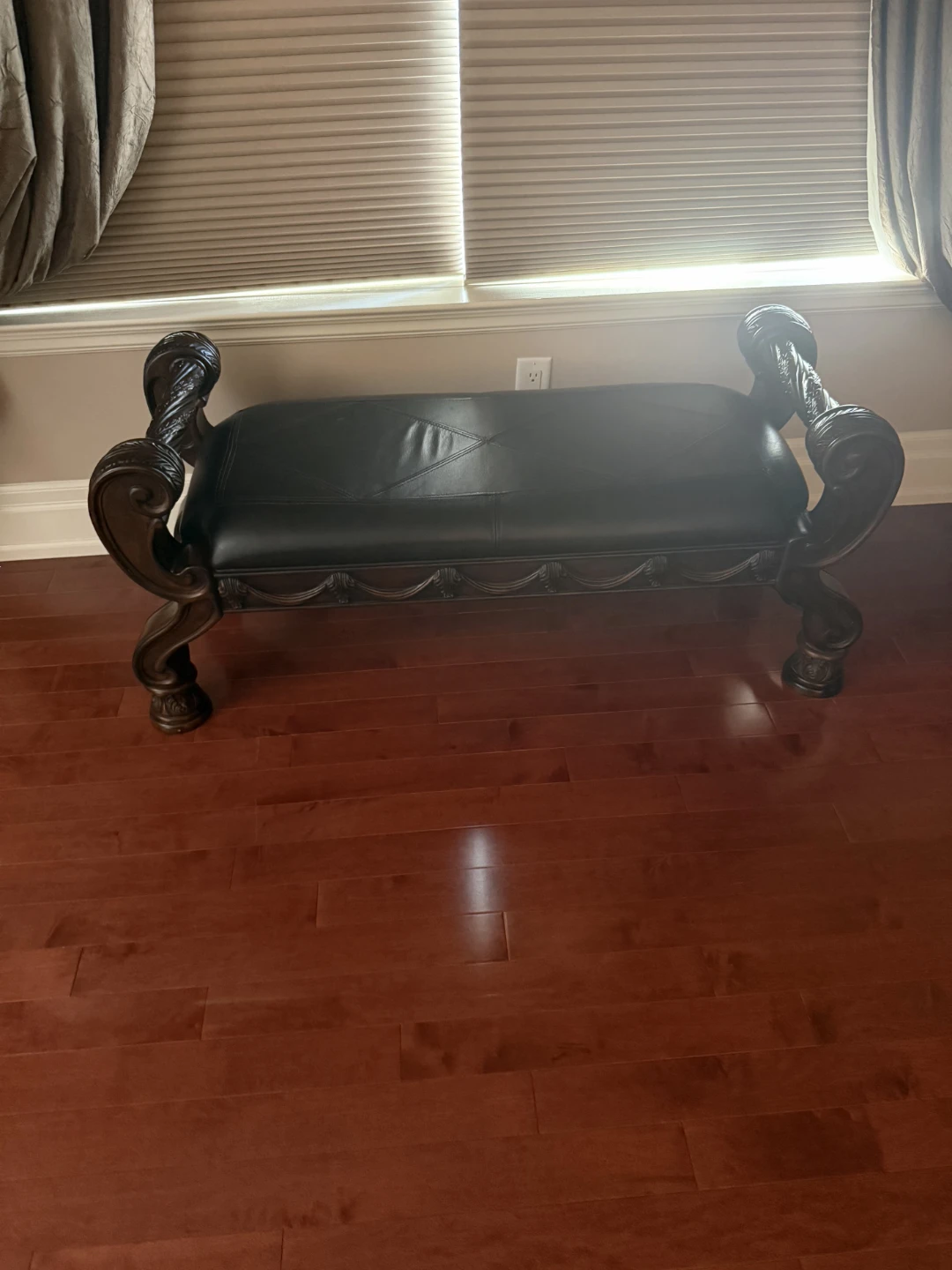Decorative bench with carved wood and black upholstery