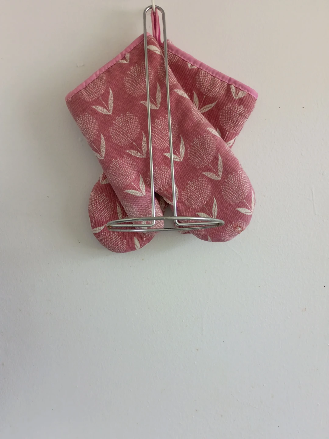 Pink floral oven mitts and kitchen napkin holder