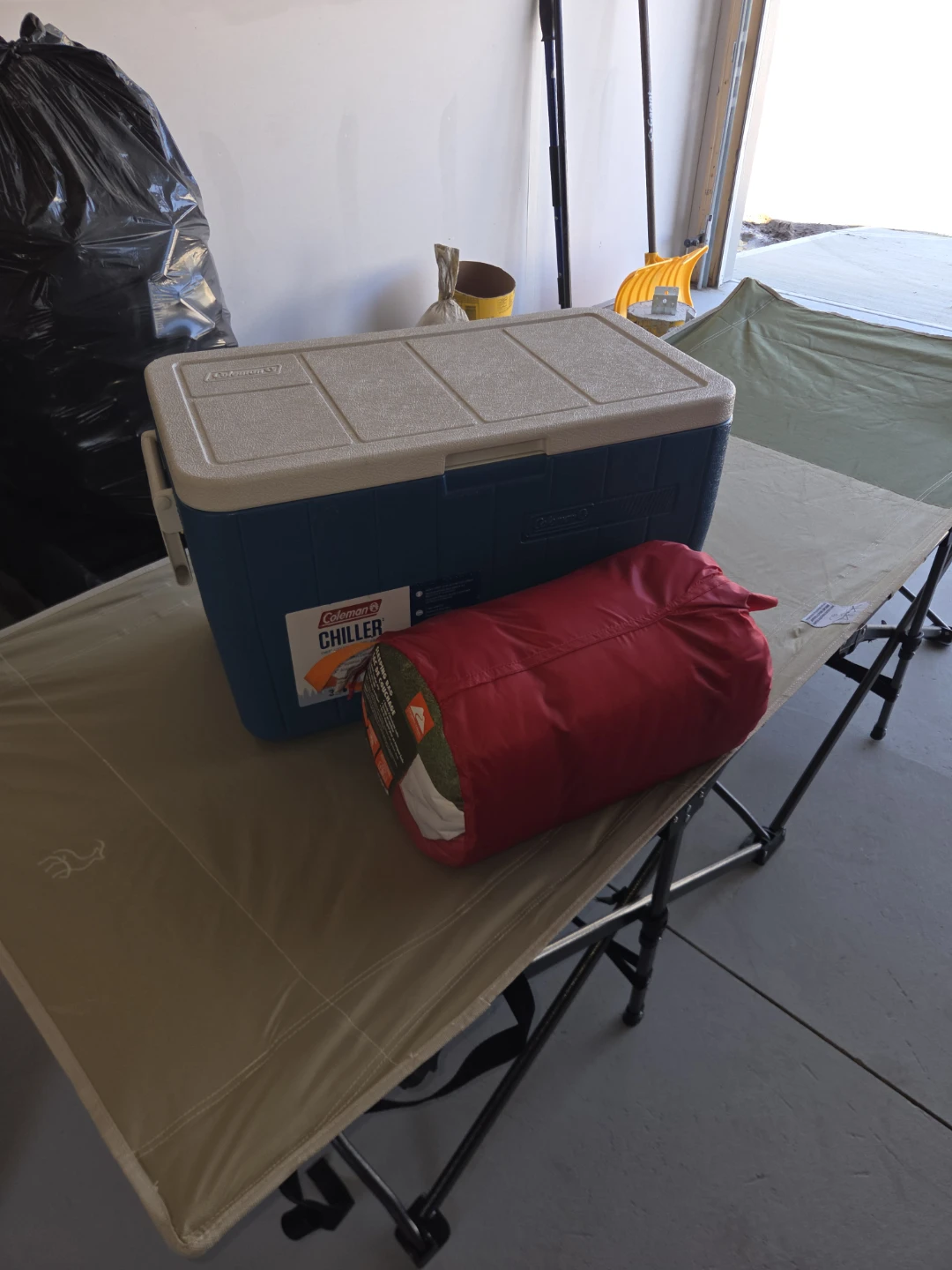 2 camping cot bed, 1 cooler and 1 sleeping bag