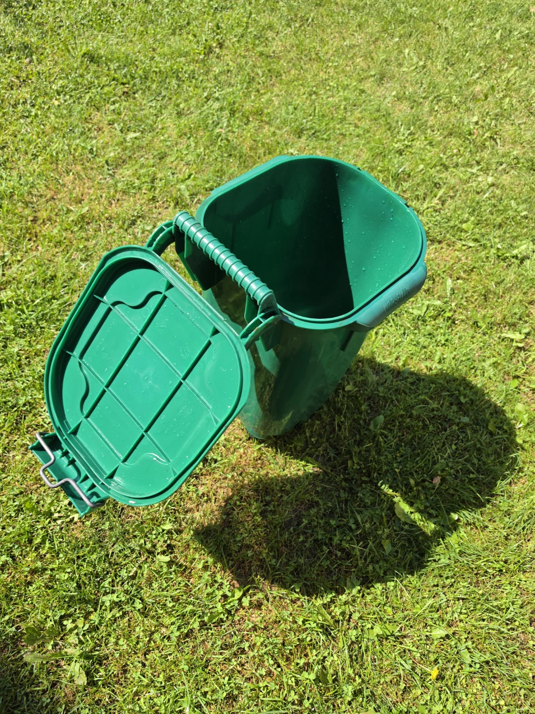 Durable green plastic compost bin with a locking lid and wheels.