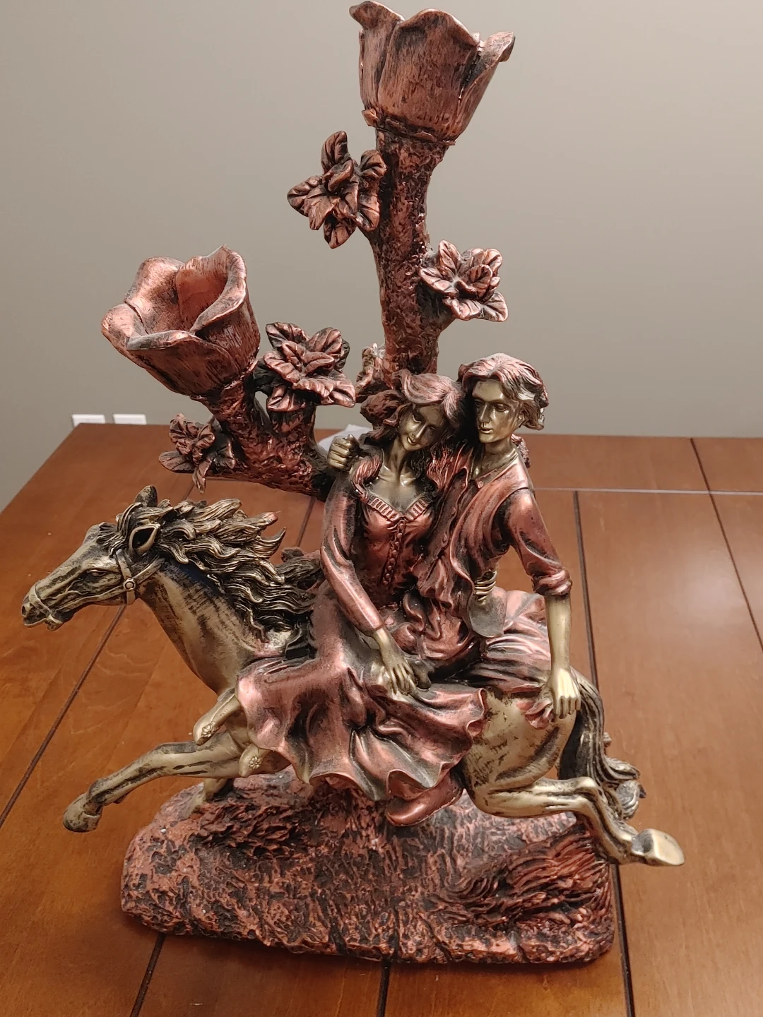 Bronze-tone couple riding a horse sculpture