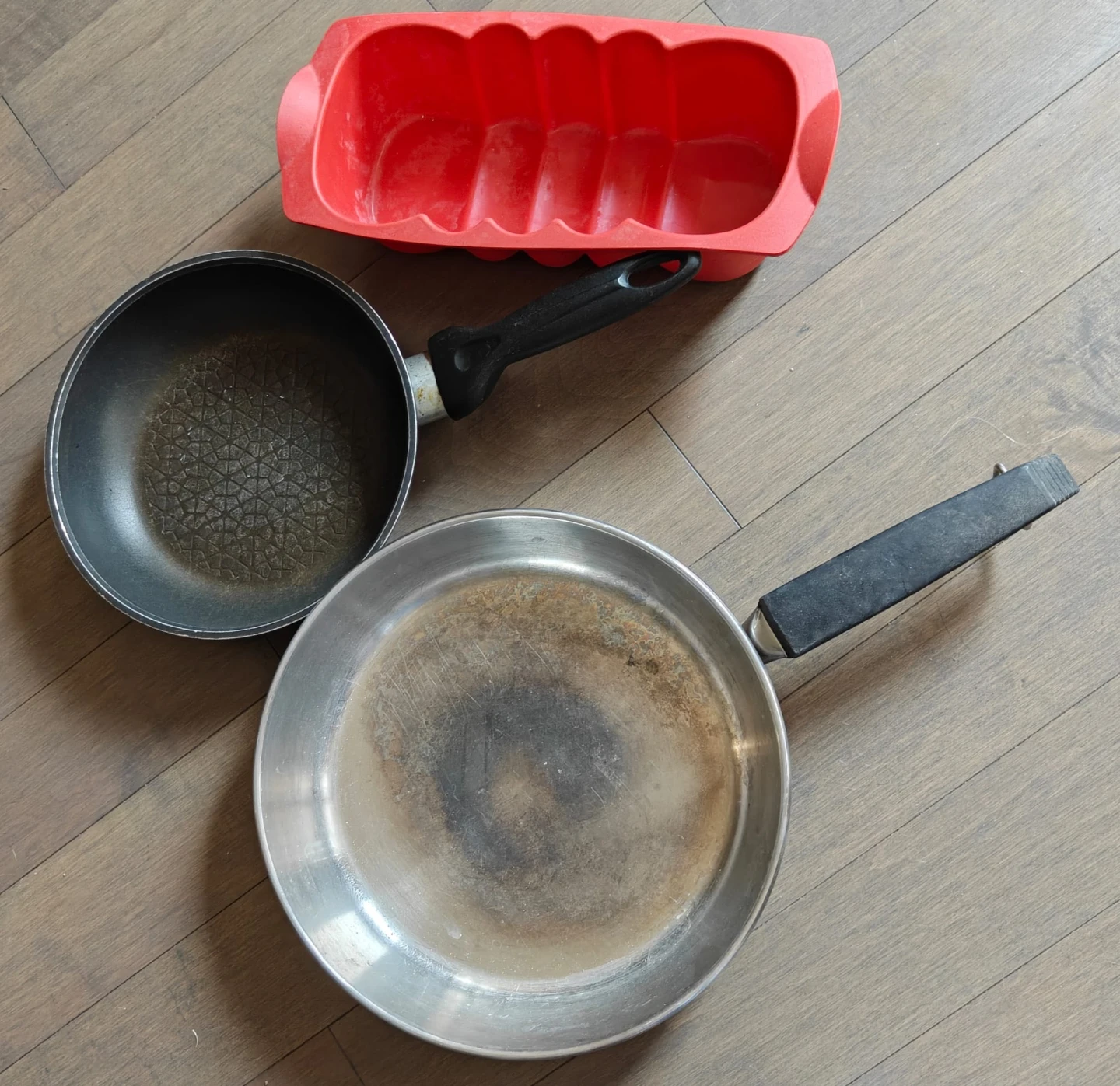 Two frying pans and a red silicone mold