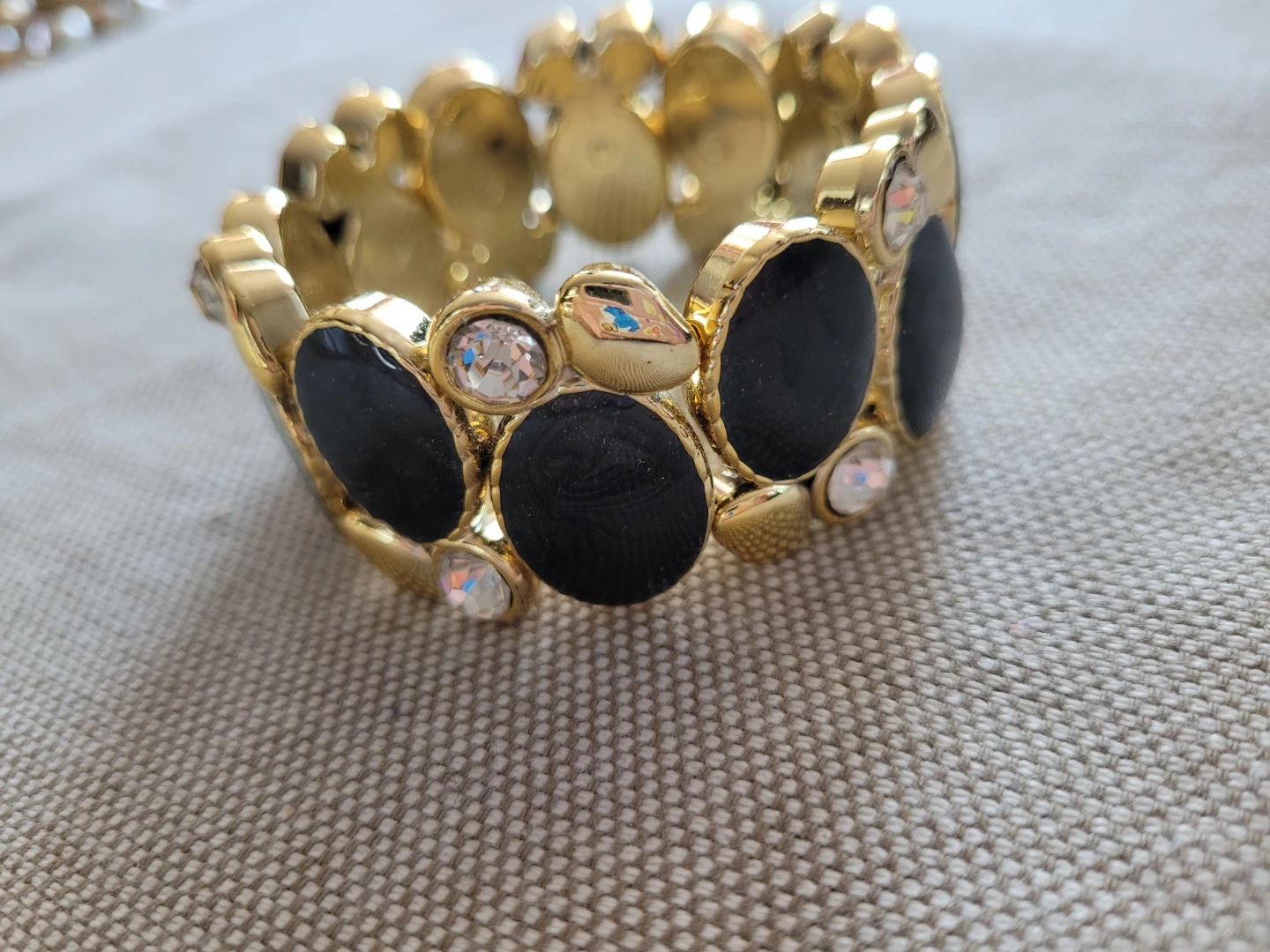Gold tone bracelet with black and clear stones