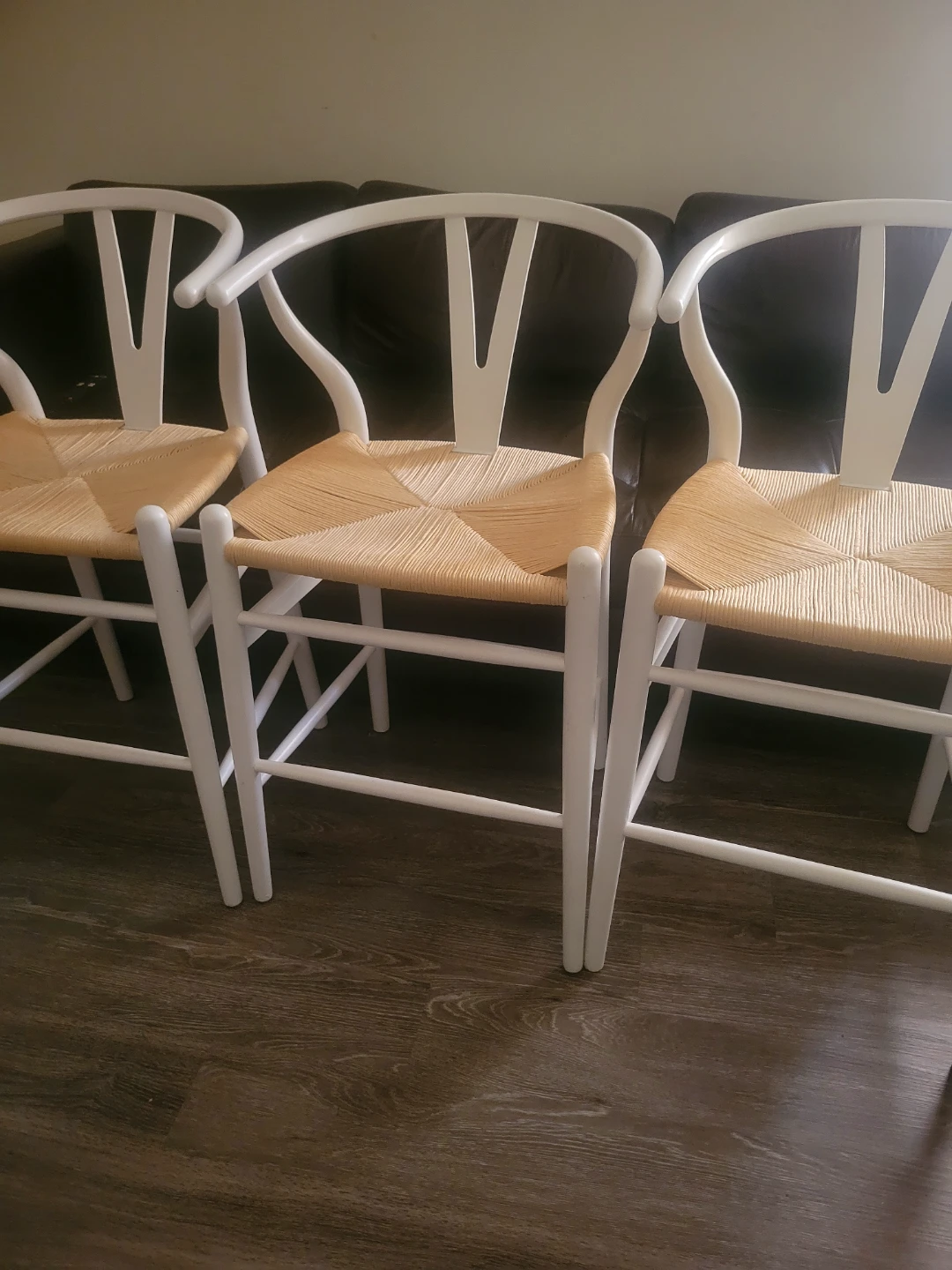 Three white counter height bone style chairs with woven seats