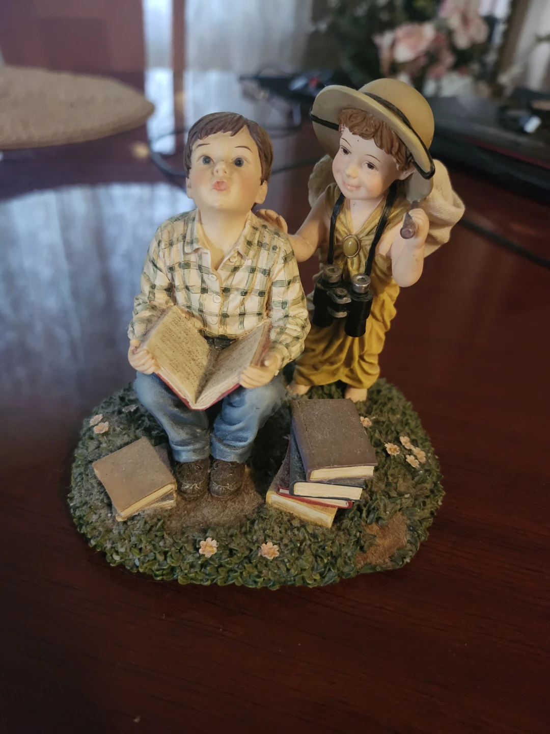 Figurine of two children reading and exploring