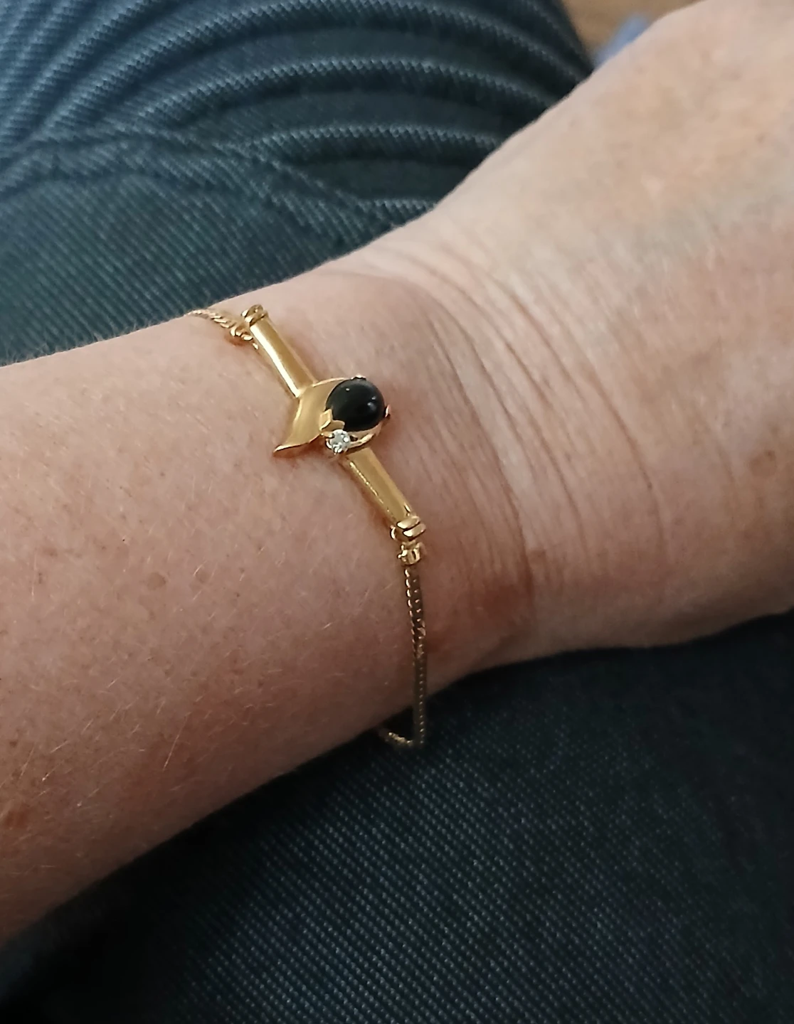 Gold-tone bracelet with black stone and diamond accent