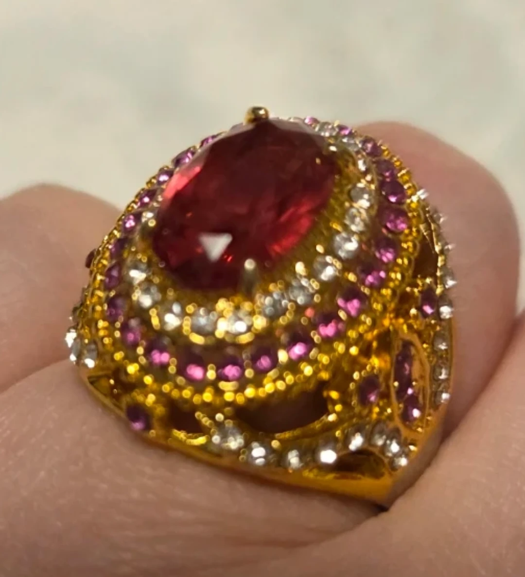 Gold-tone ring with red and pink stones