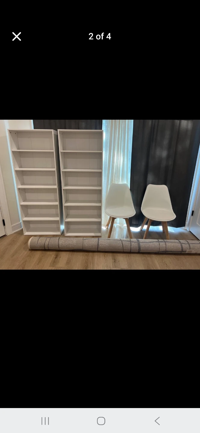 Two white bookshelves and two white chairs