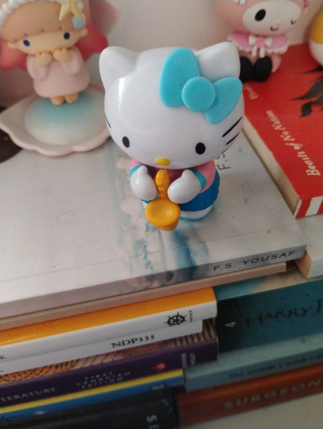Hello Kitty toy with blue bow and saxophone