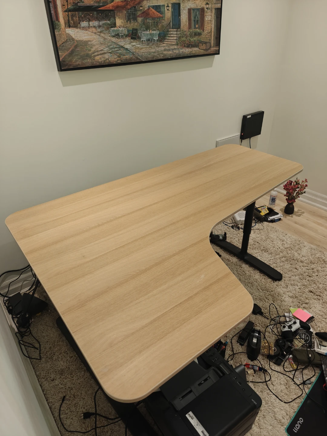 L-shaped standing desk with light wood finish