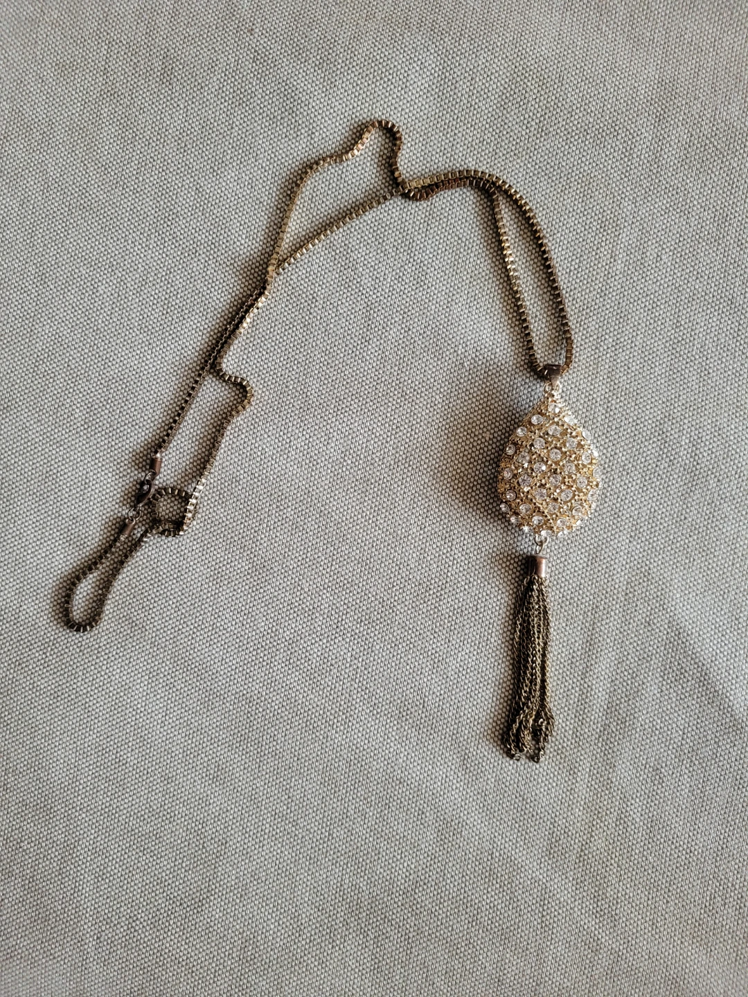 Gold tone pendant necklace with tassel and rhinestones