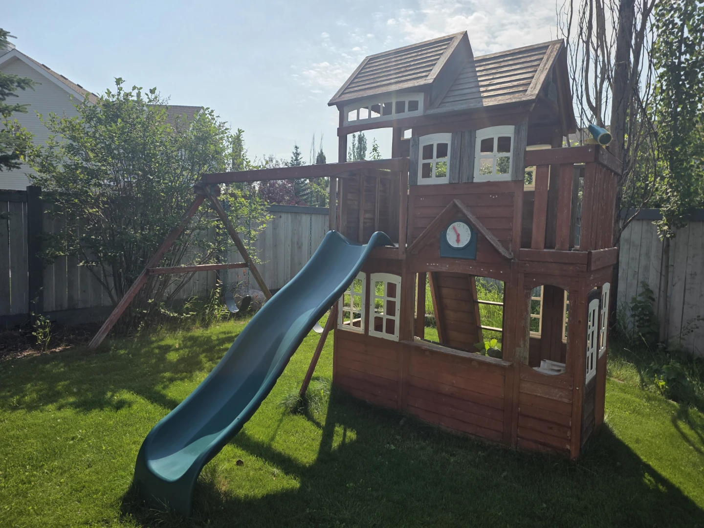 Wooden backyard playground with slide and swing