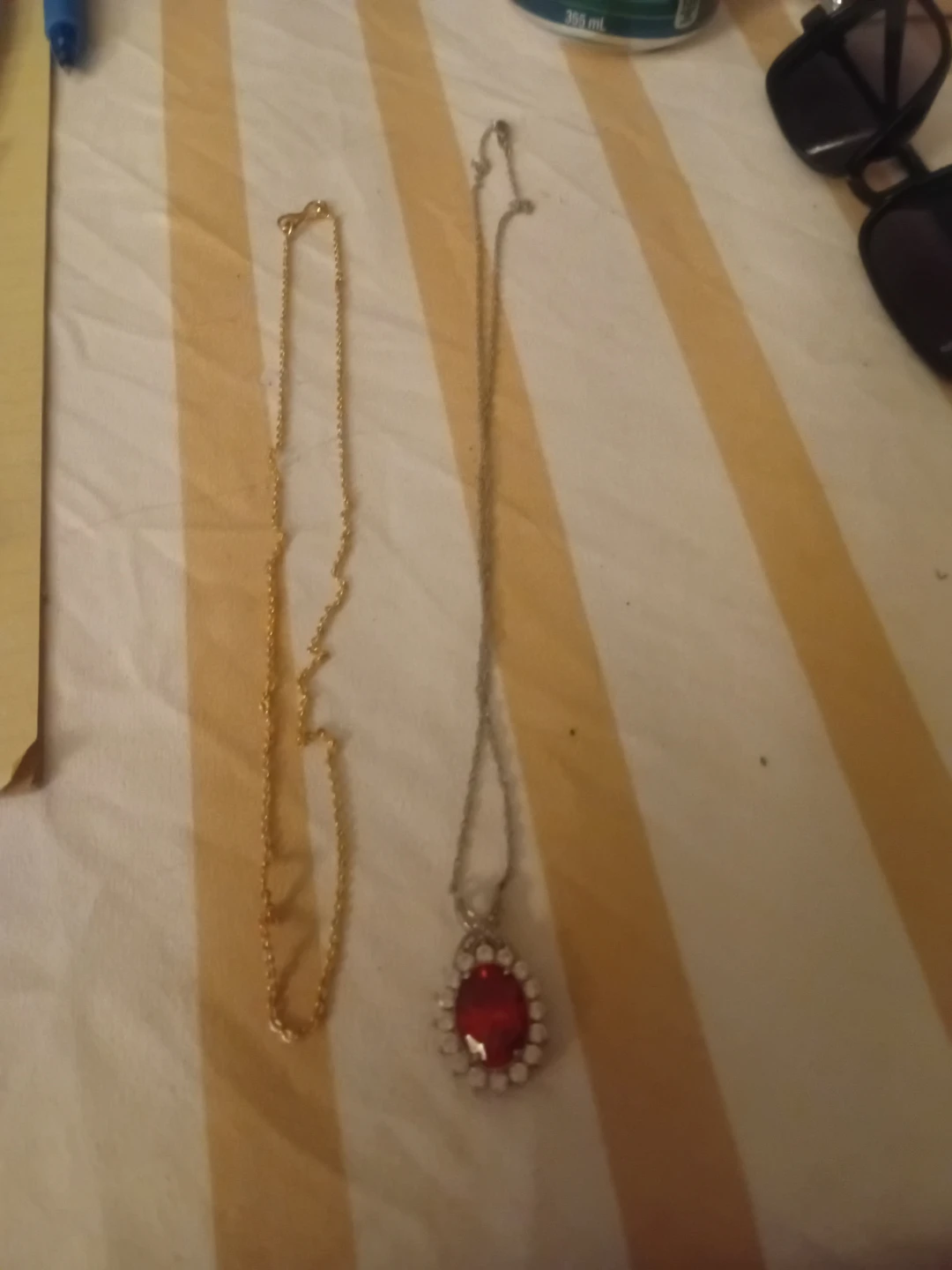 Two necklaces: gold chain and red pendant necklace