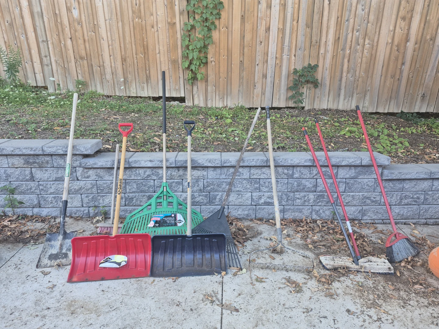 Assorted Snow Shovels, Rakes, and Brooms