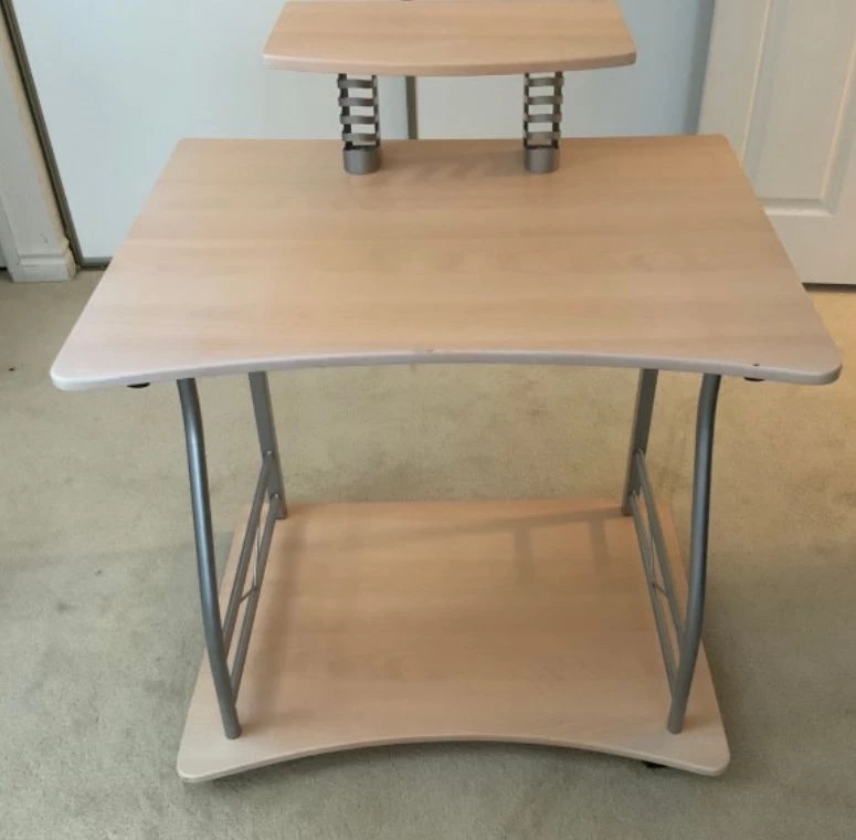 Compact computer desk features a sleek, light wood-grain