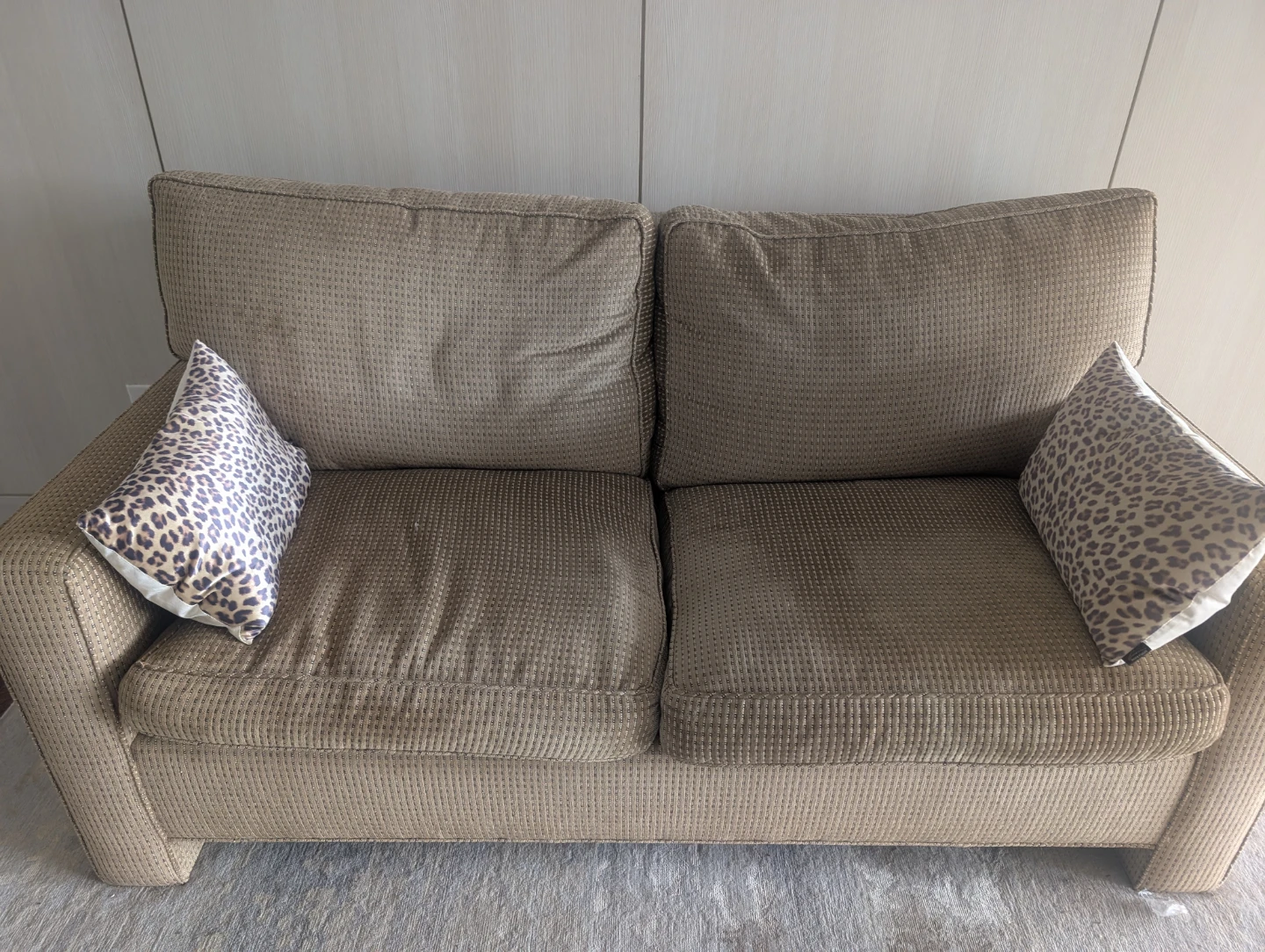 Brown textured loveseat with two throw pillows