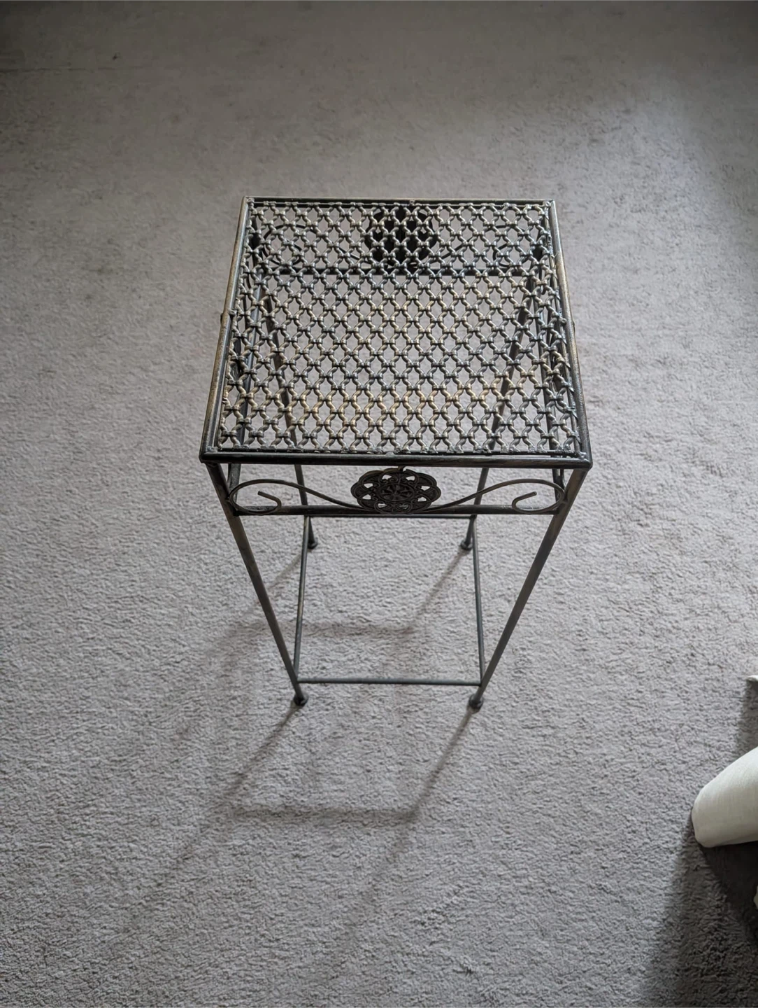 Tall metal stand for plants, lamps or other objects.