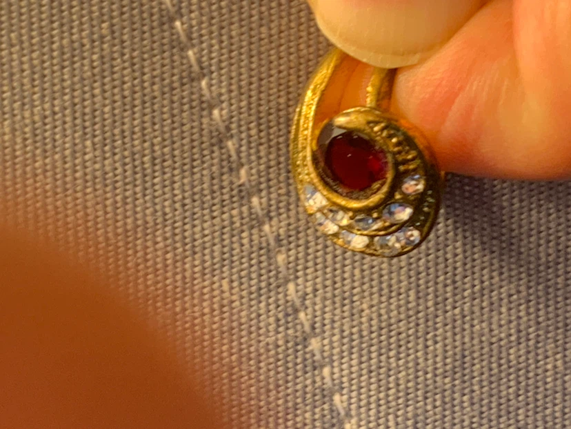 Gold tone swirl ring with red stone