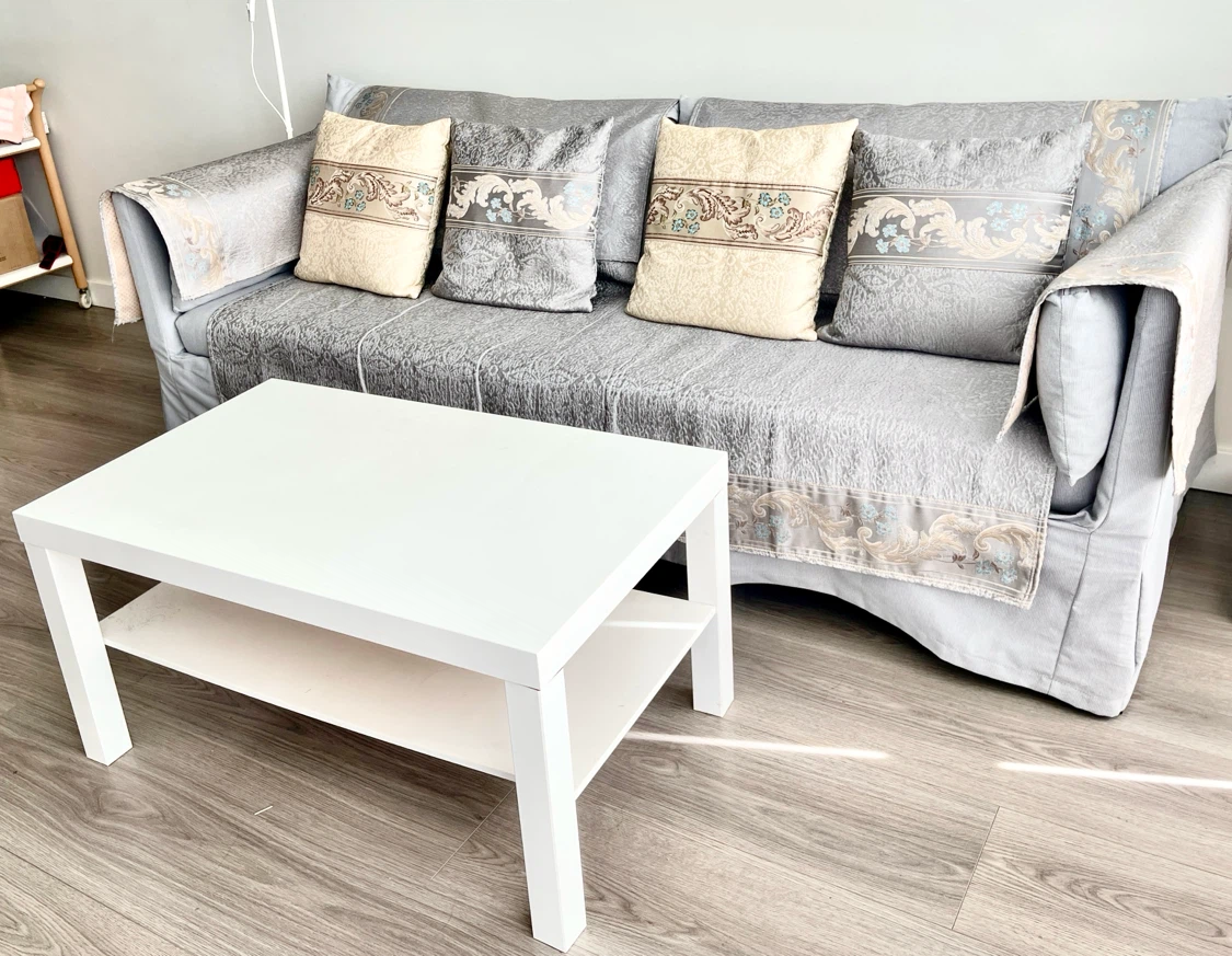 An set three-seater sofa and a wooden tea table