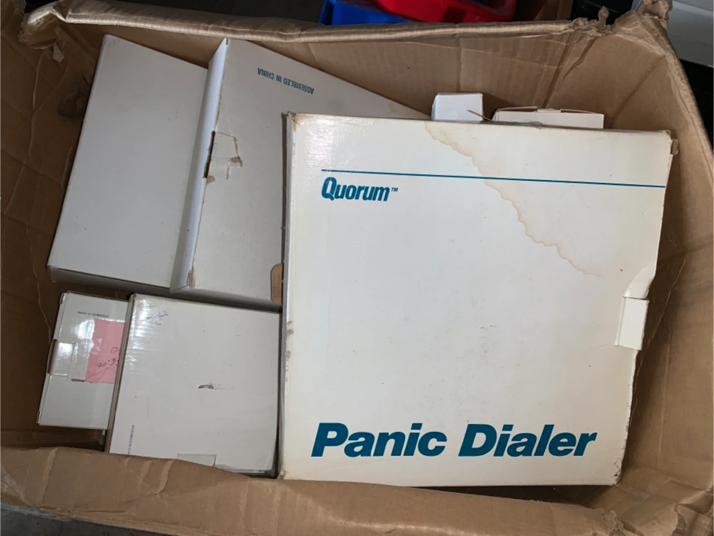 Box of vintage alarm system devices. Quorum