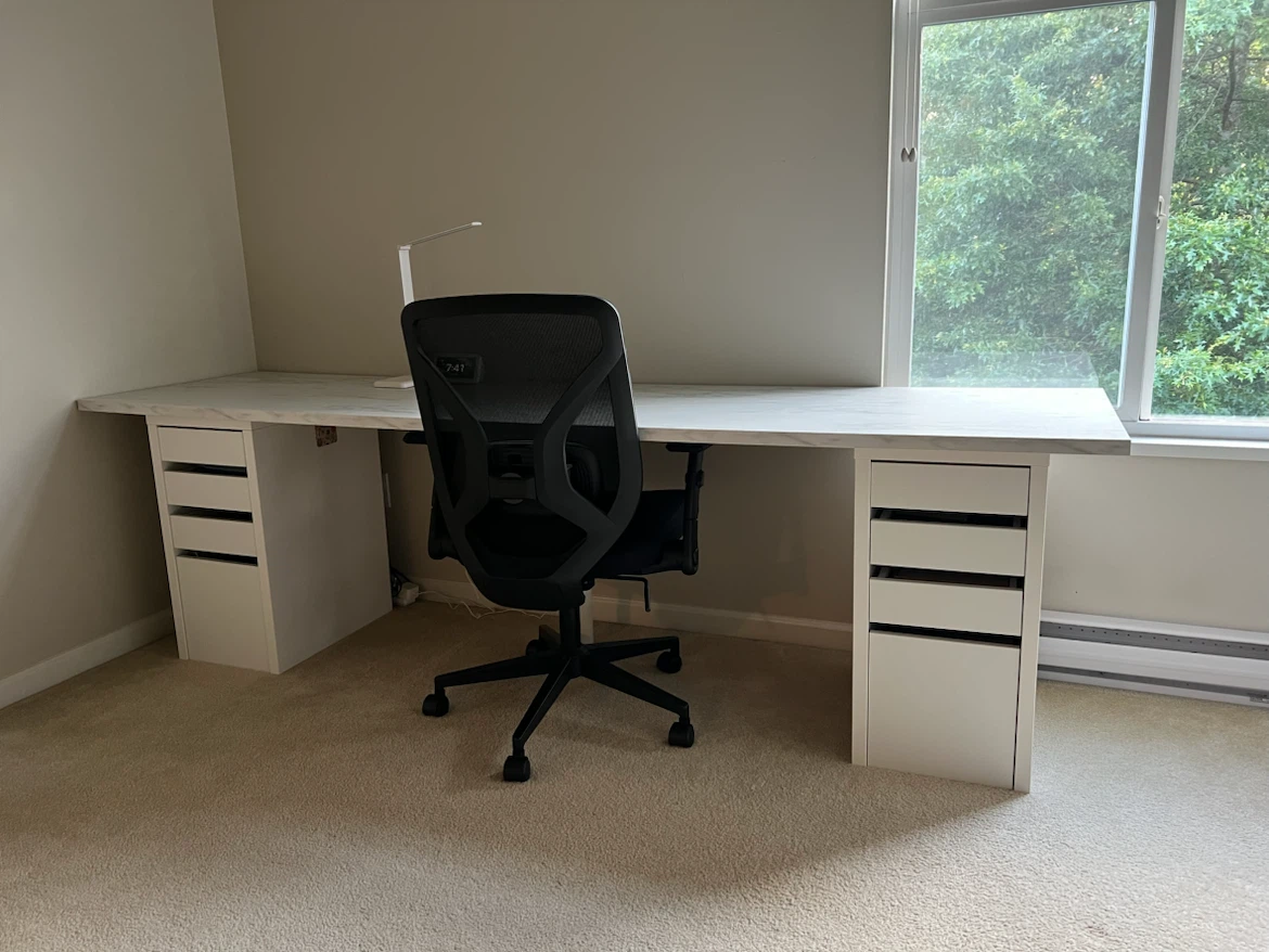Large white desk with marble-look top and storage drawers