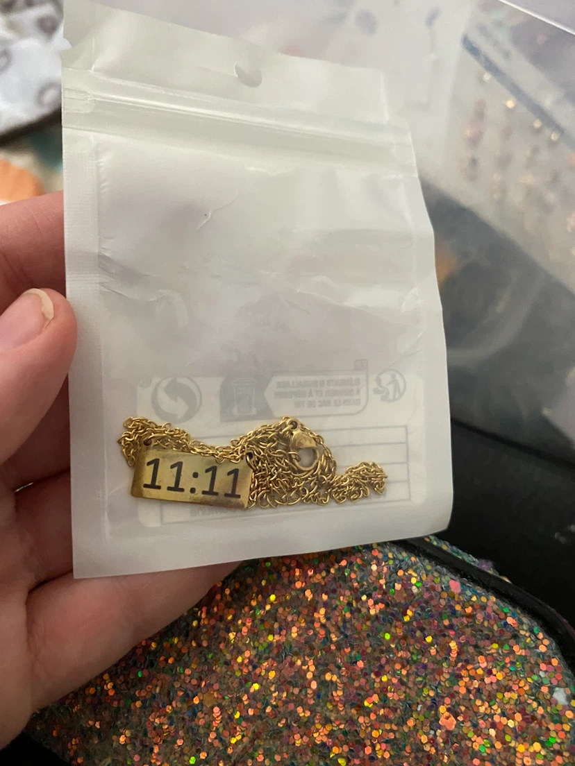 Gold tone necklace with "11:11" pendant