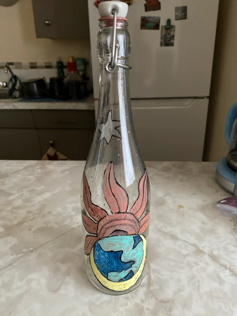 Clear glass swing-top bottle with Earth and sun design
