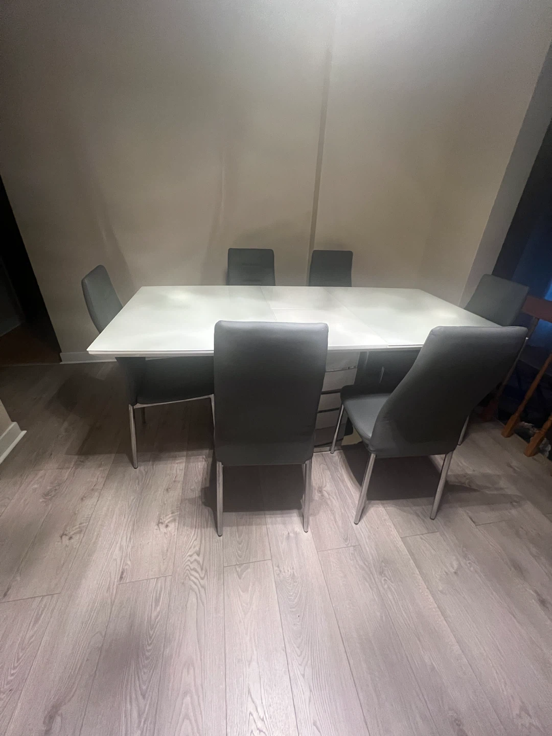 white dining table with 6 grey leather chairs