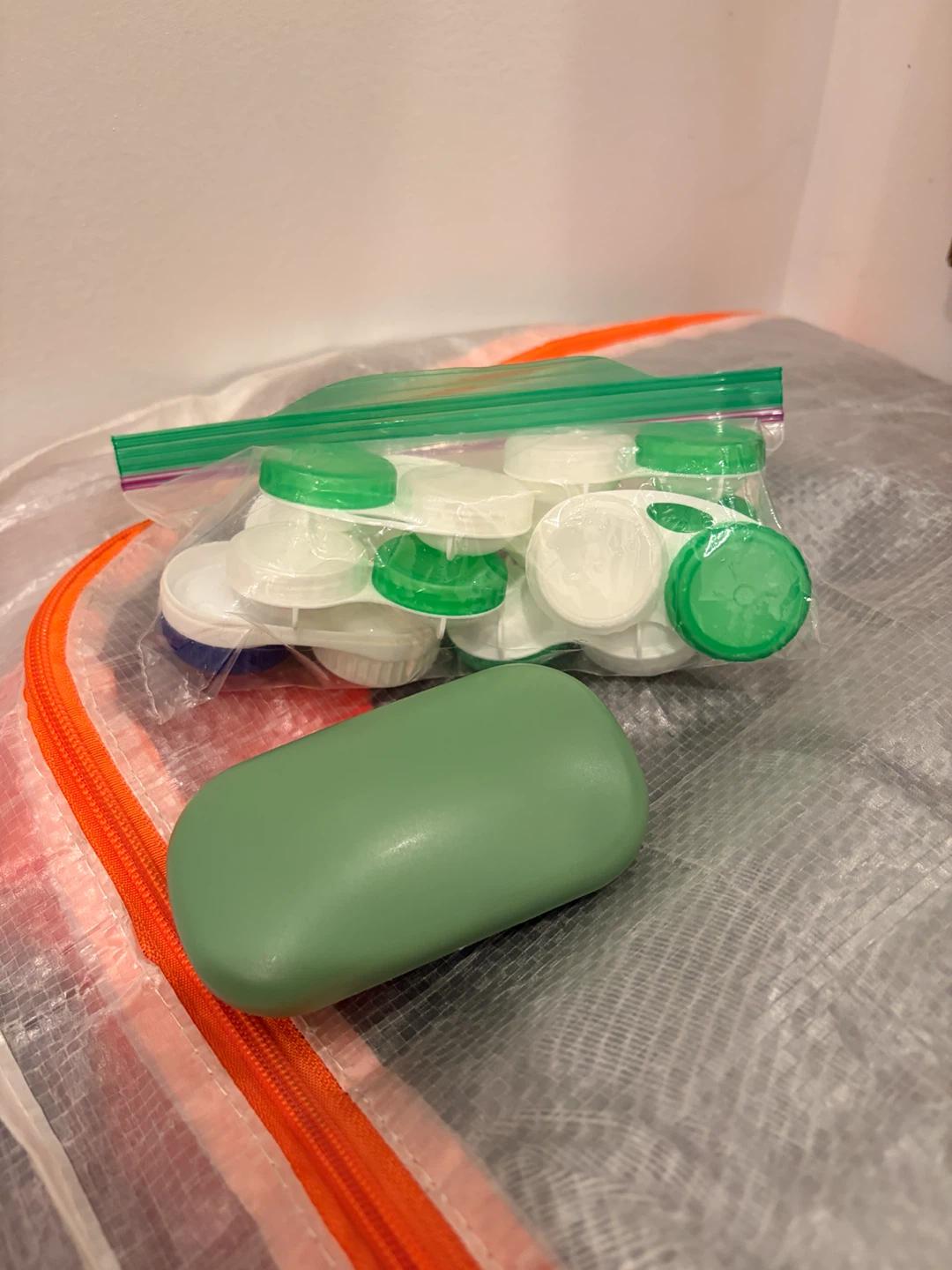 Handful of contact lens cases + Green Pill Organizer