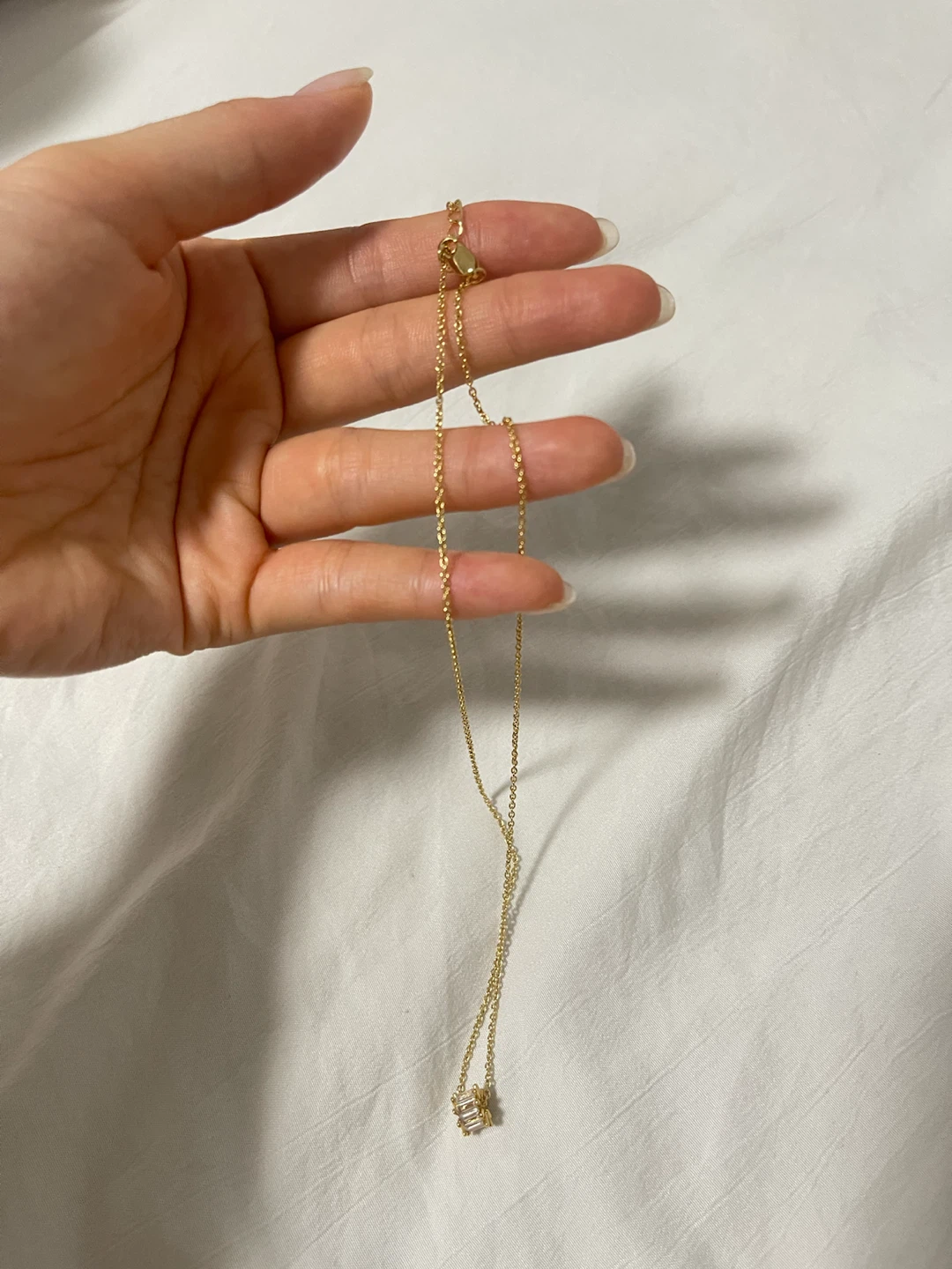 Gold-tone necklace with clear baguette crystal pendant