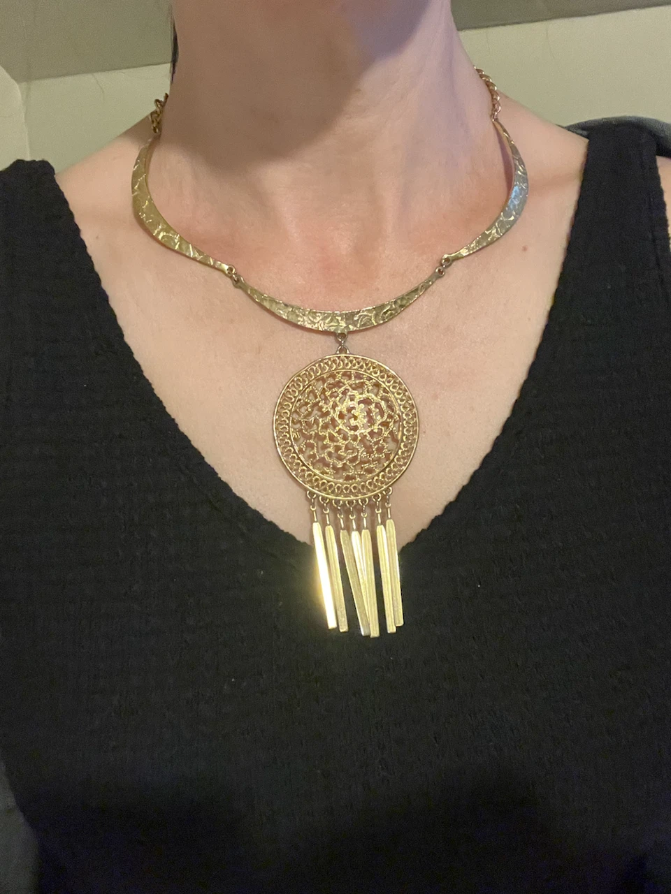 Gold-tone statement necklace with ornate pendant