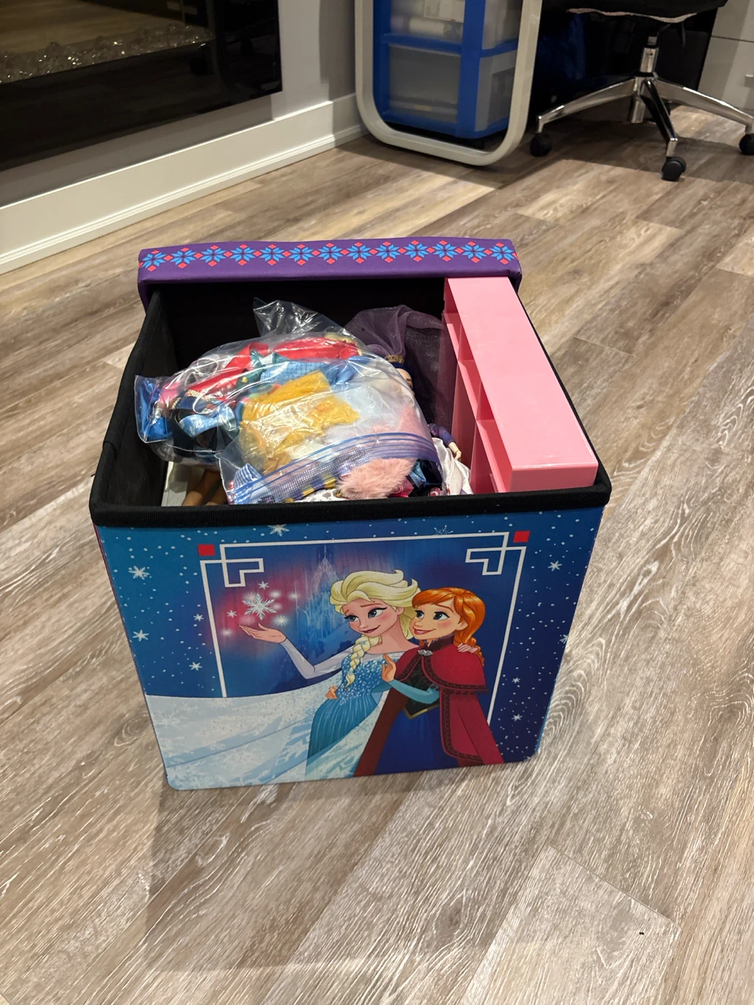 Storage box filled with Barbies, exercises and furniture
