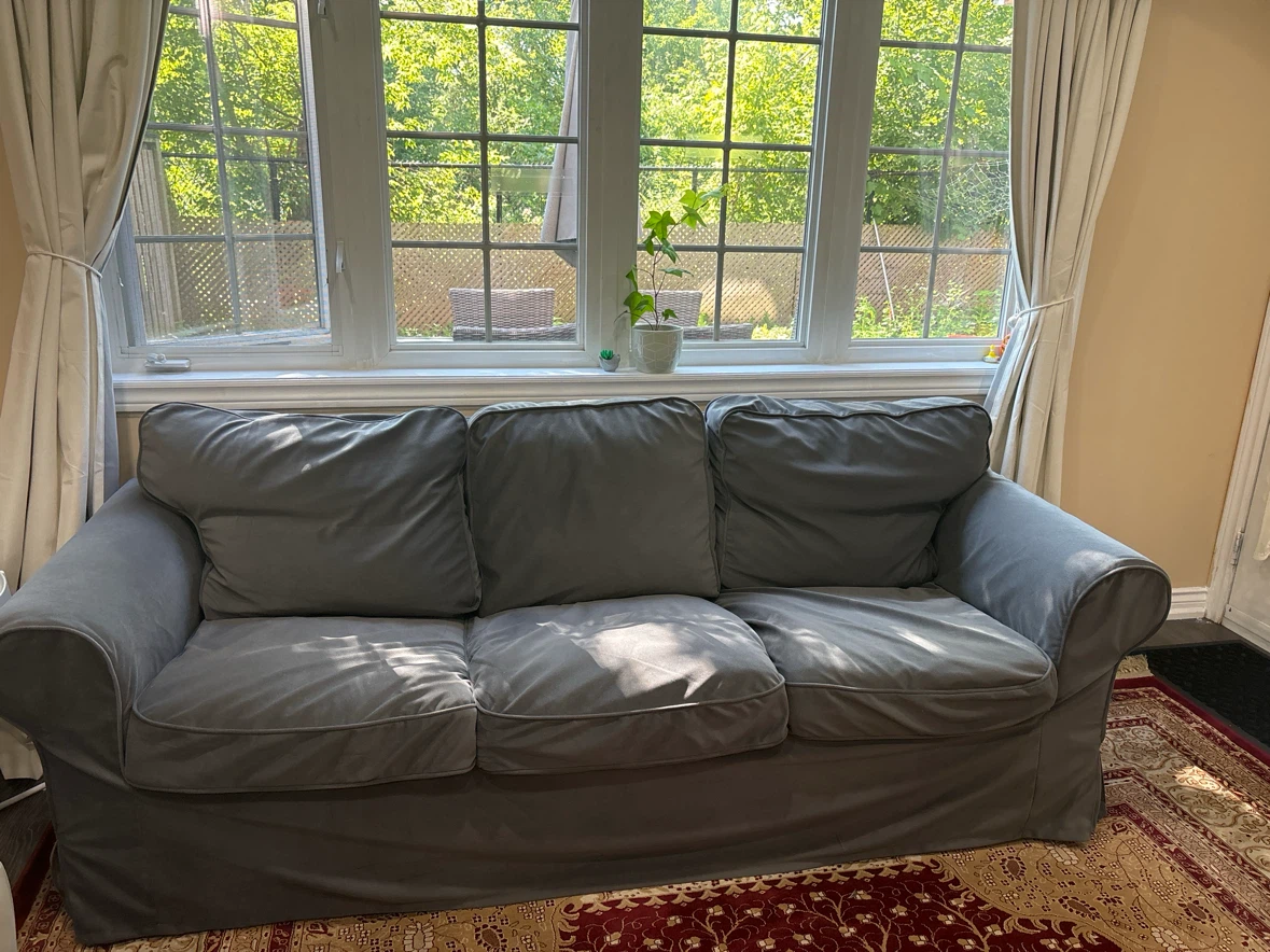 Grey three-seater sofa with removable cover