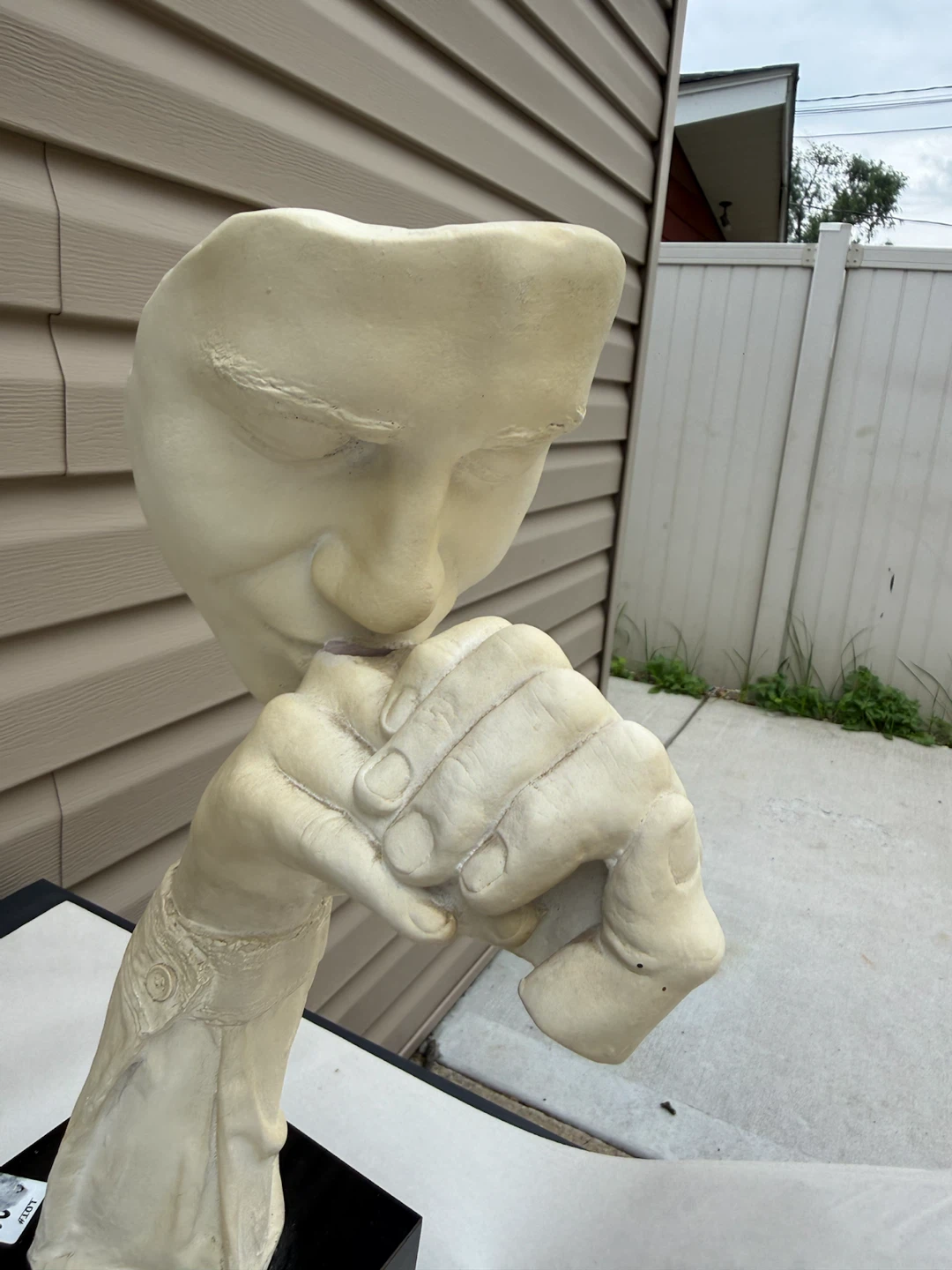 Sculpture of a face with hand over mouth - photo 2