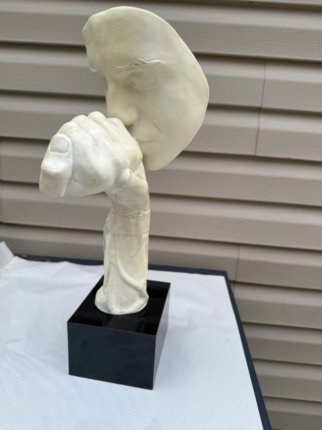 Sculpture of a face with hand over mouth - photo 3