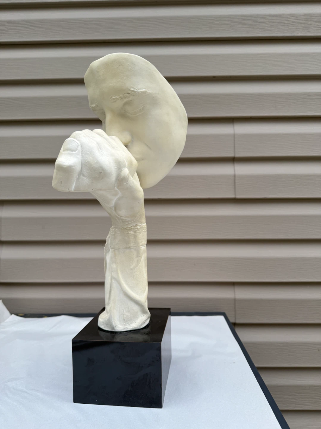 Sculpture of a face with hand over mouth - photo 4
