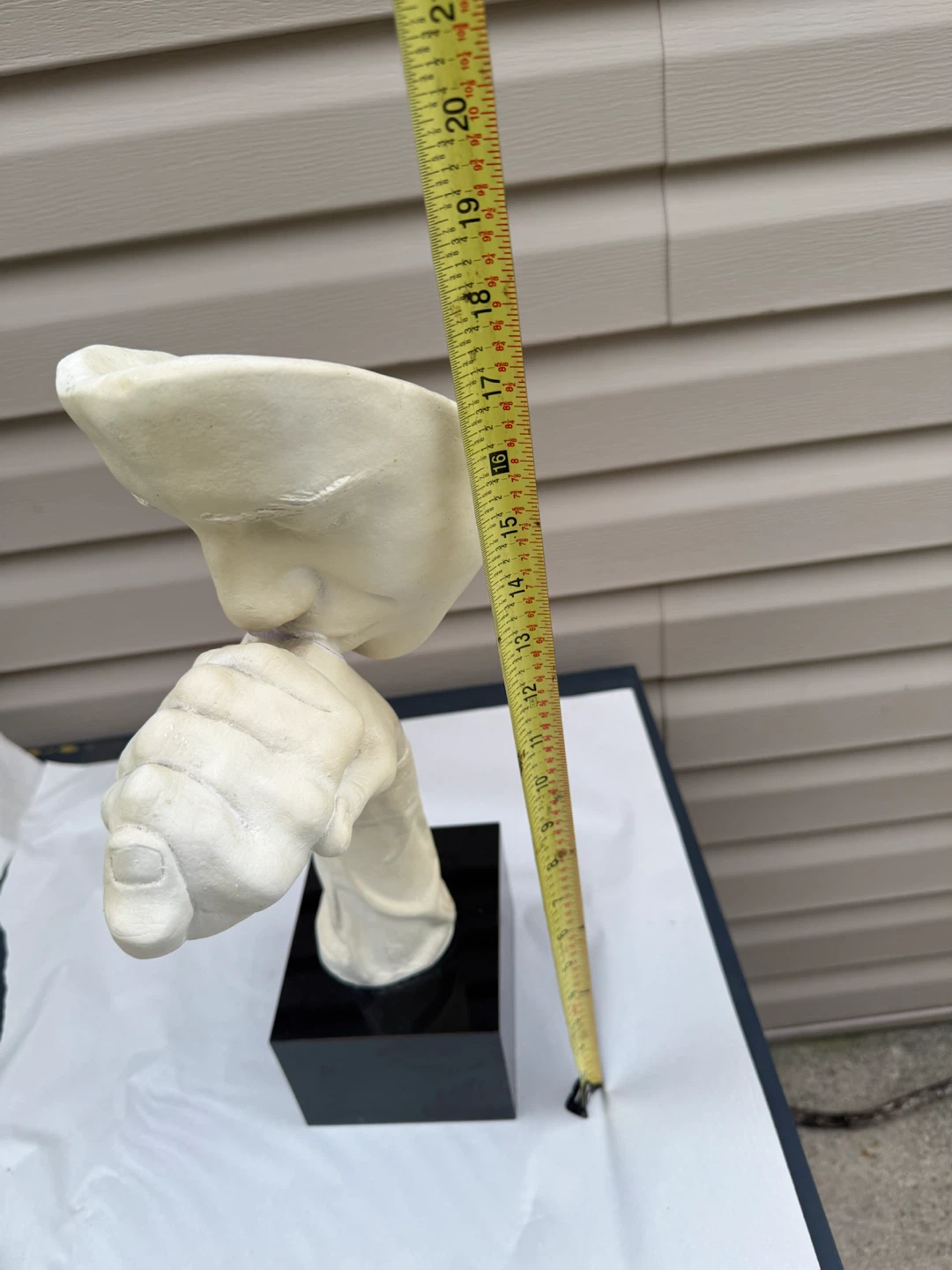 Sculpture of a face with hand over mouth - photo 5