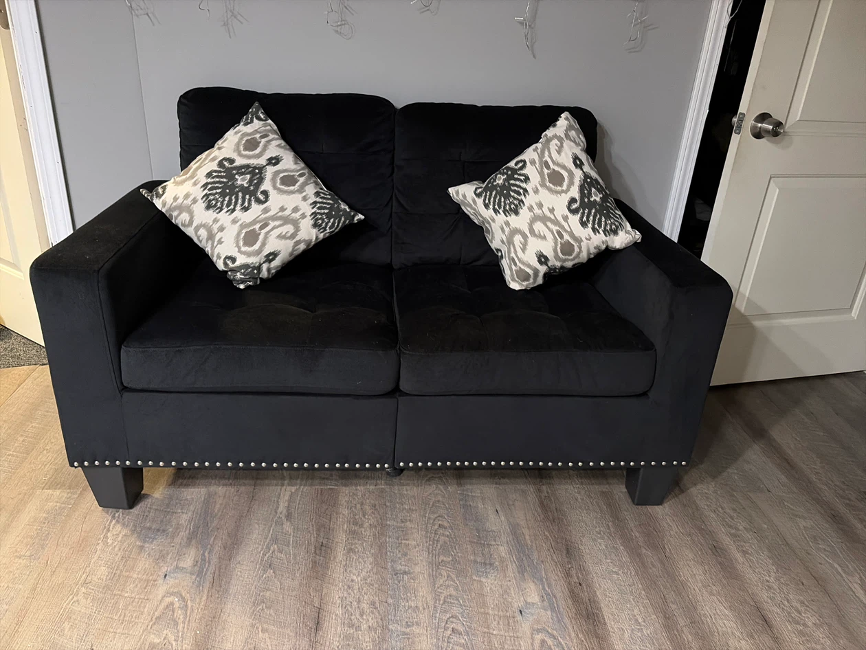 Black Tufted Loveseat with Decorative Pillows there are two