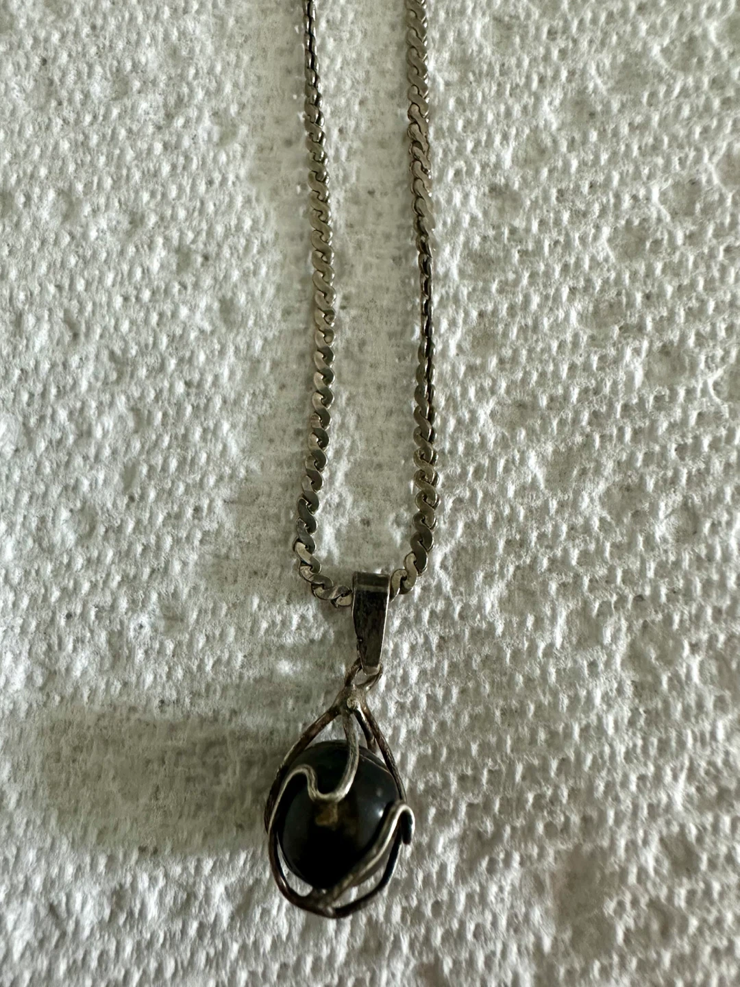 Silver tone necklace with dark stone pendant