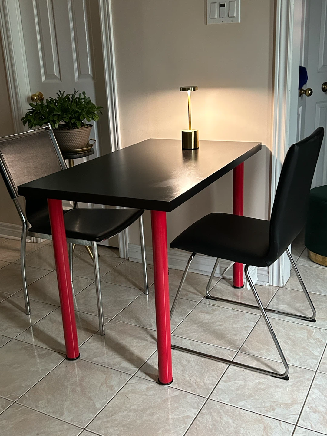 Black Dining Table with Red Legs and two moder leather chairs
