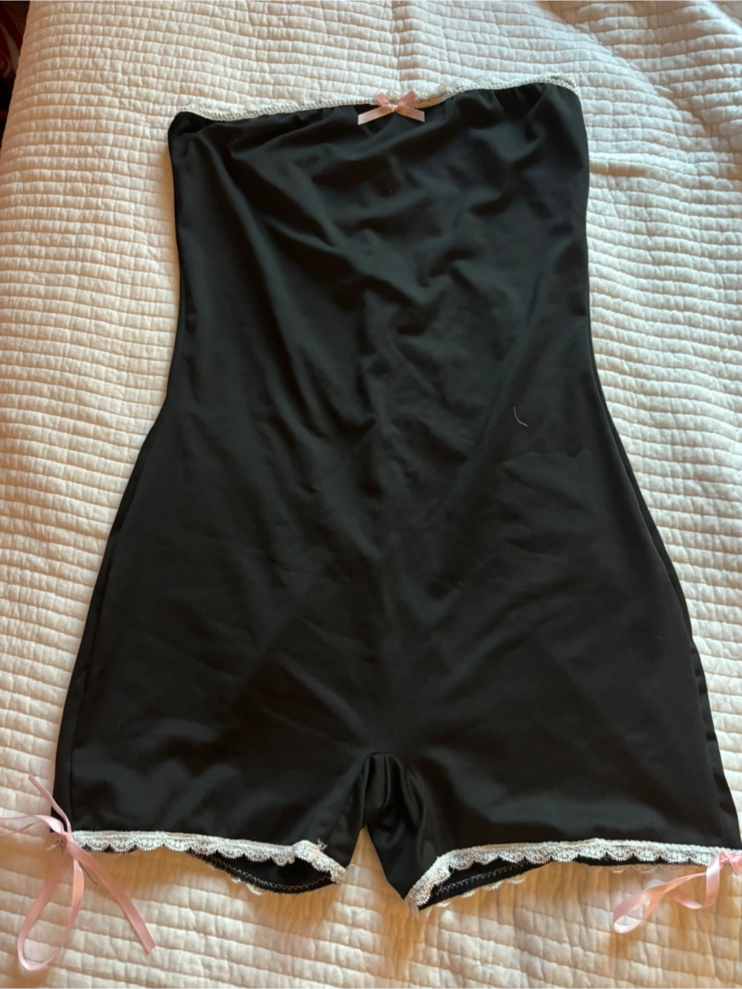 Black lingerie romper with lace trim and pink bows