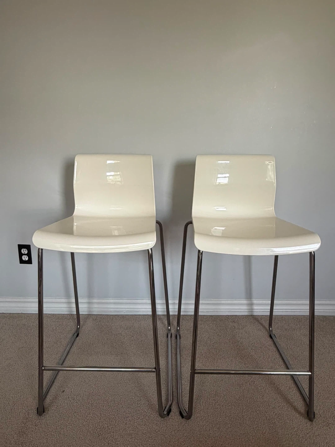 Two Ikea white bar stools with metal legs