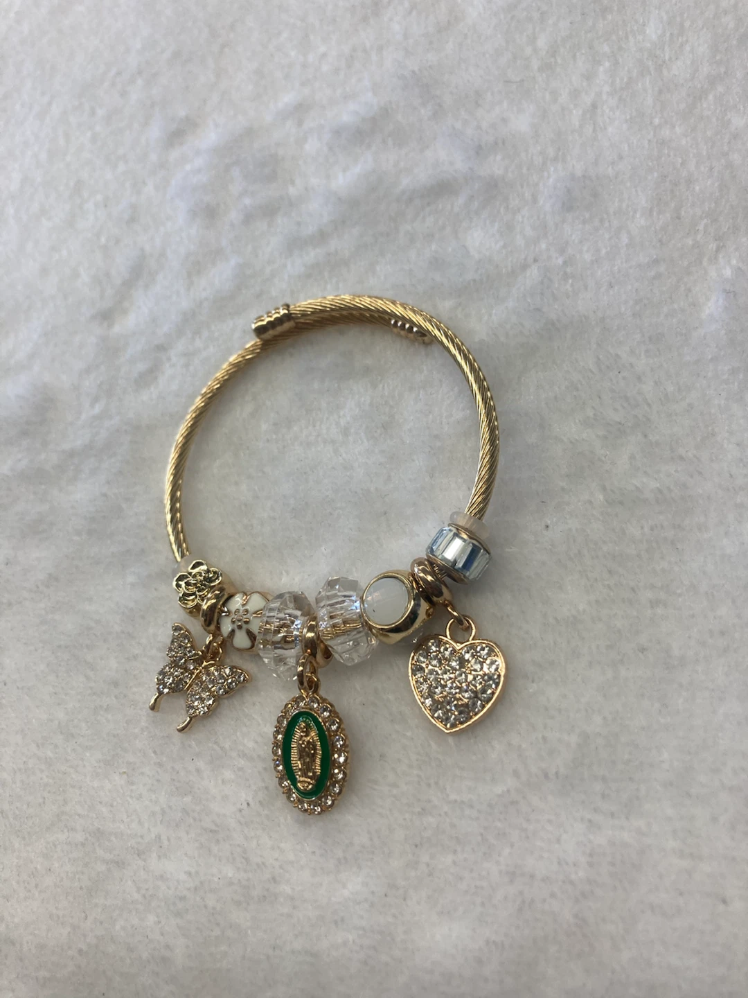 Gold tone charm bracelet with , heart, and Virgin Mary charms