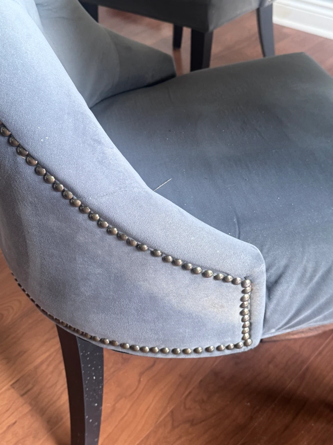 Four upholstered dining chairs with rivets
