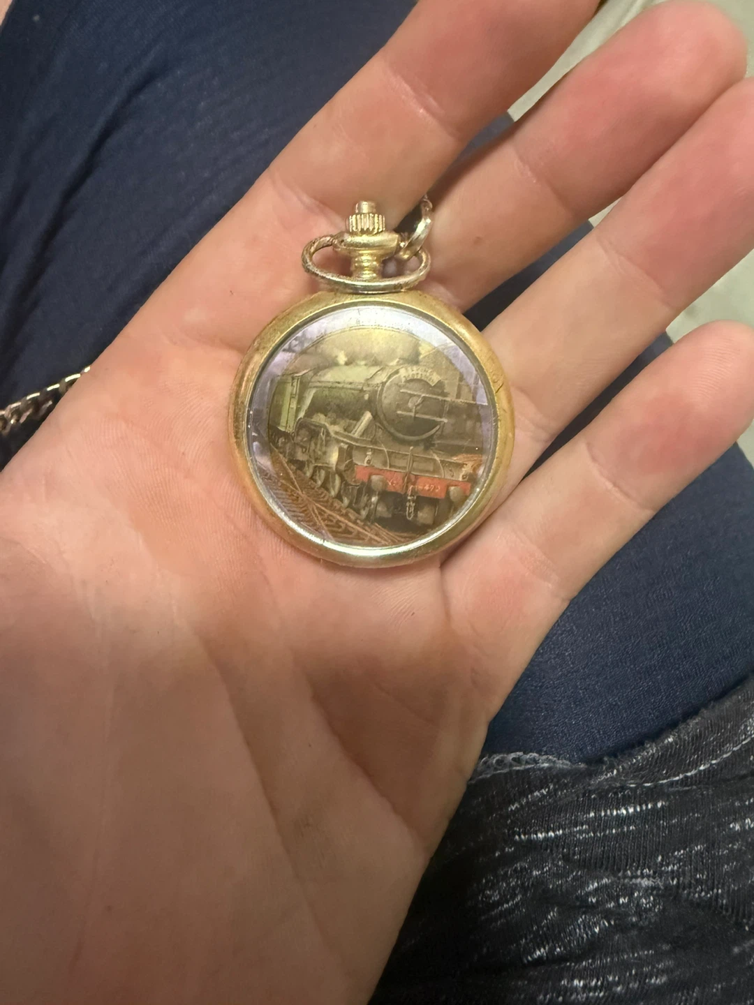 Gold-tone pocket watch with train image