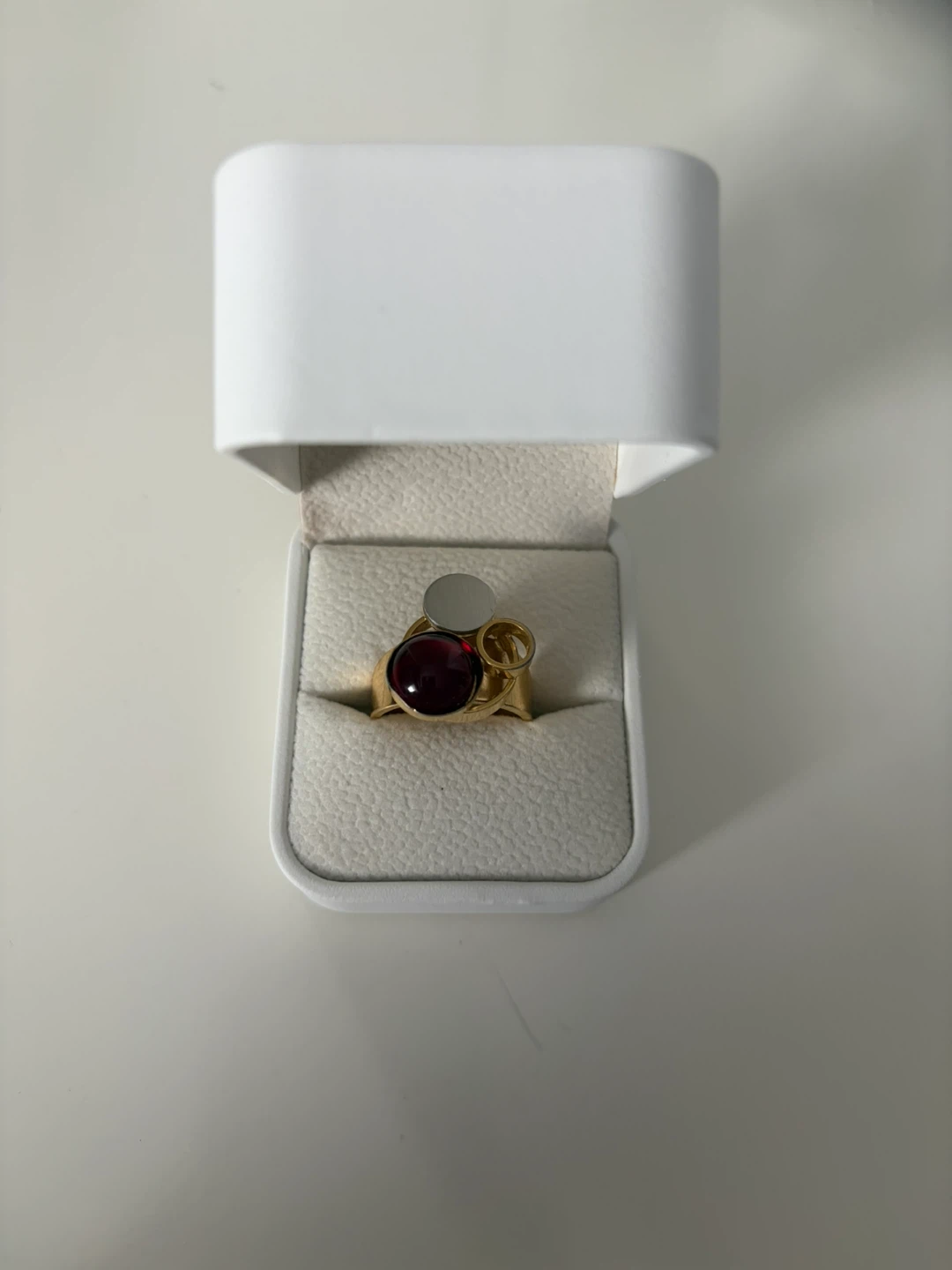 Gold-tone ring with red stone and silver accent