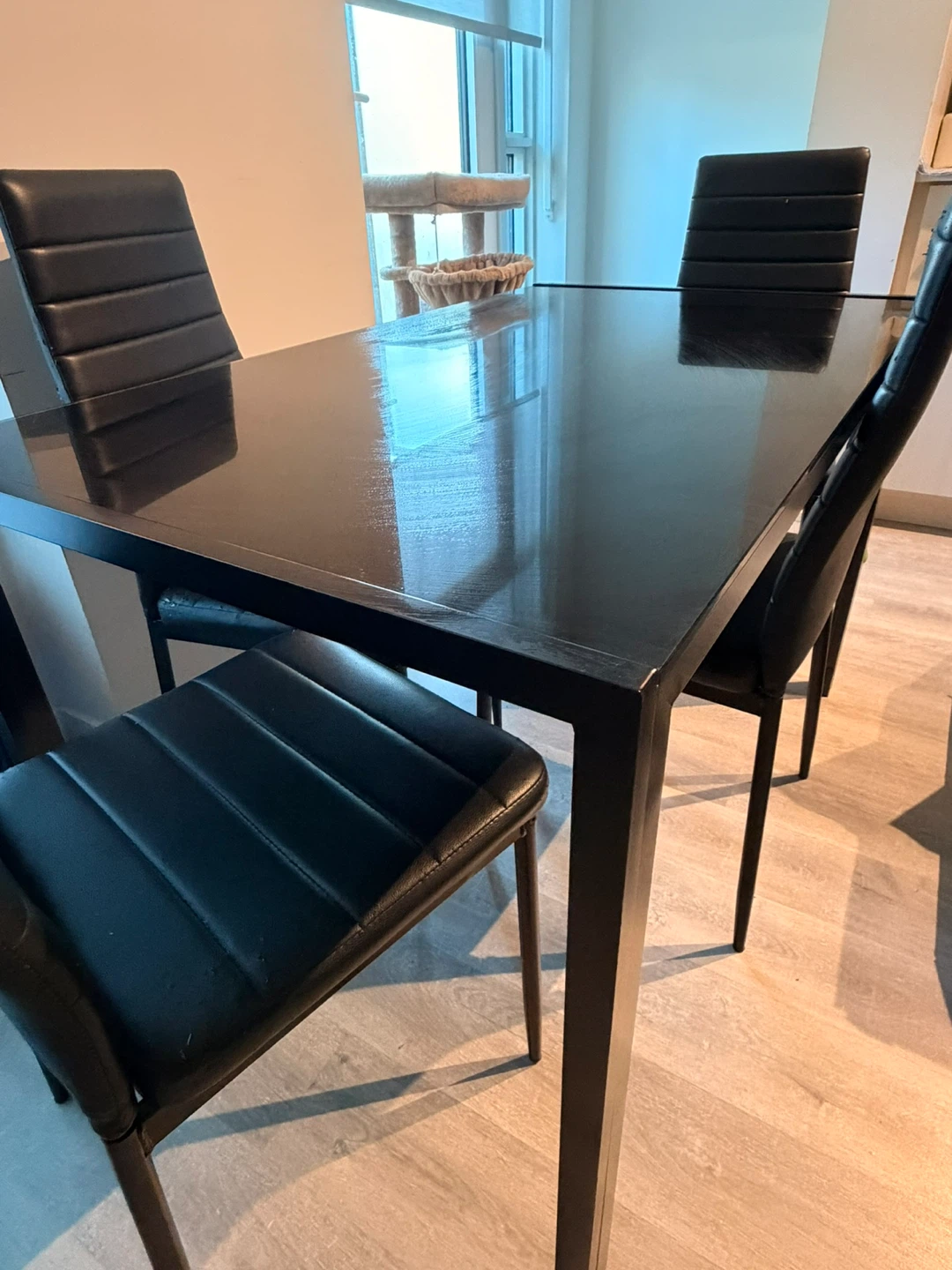 Black glass top dining table with four chairs