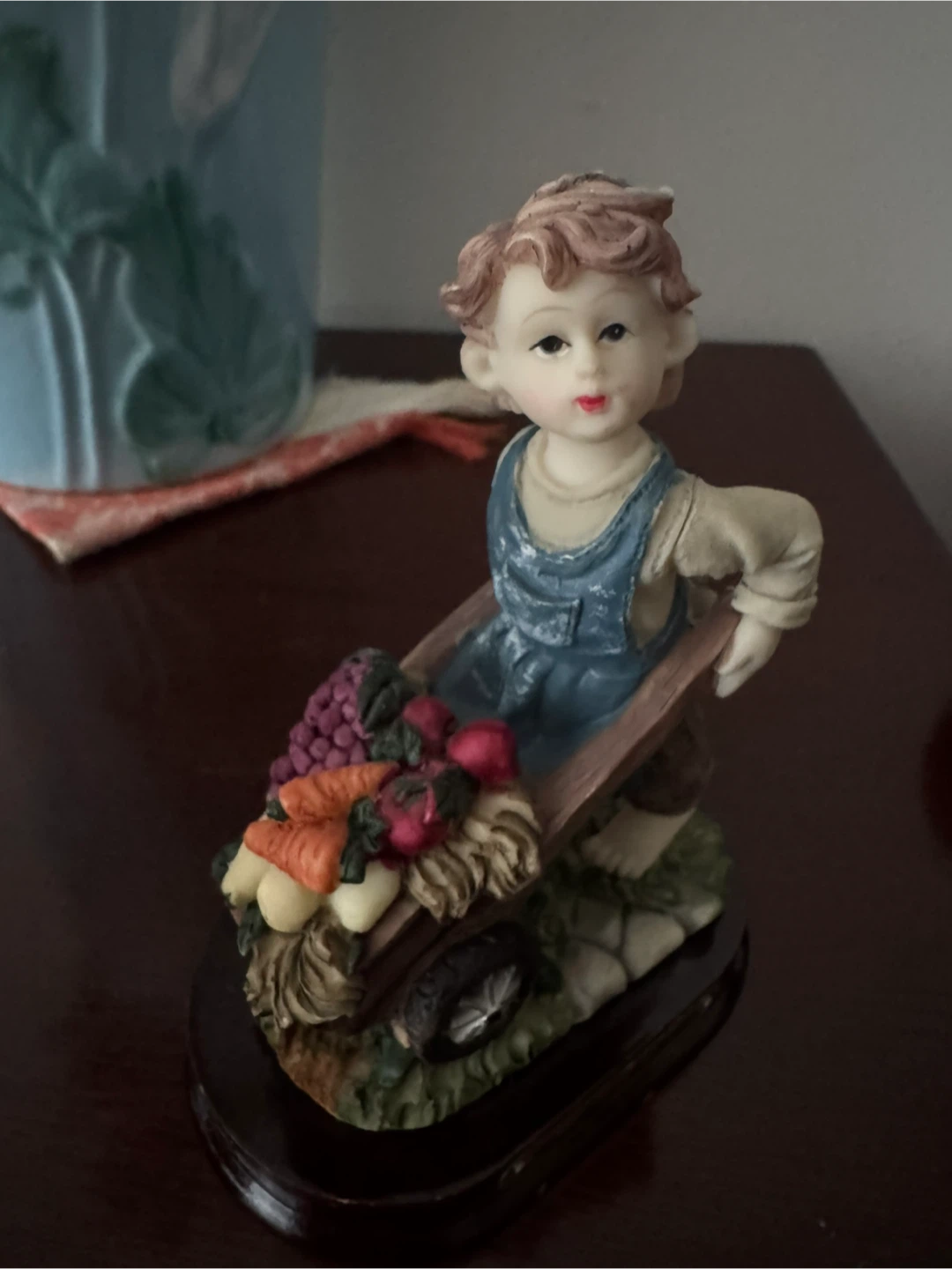 Figurine of a boy with a wheelbarrow of vegetables